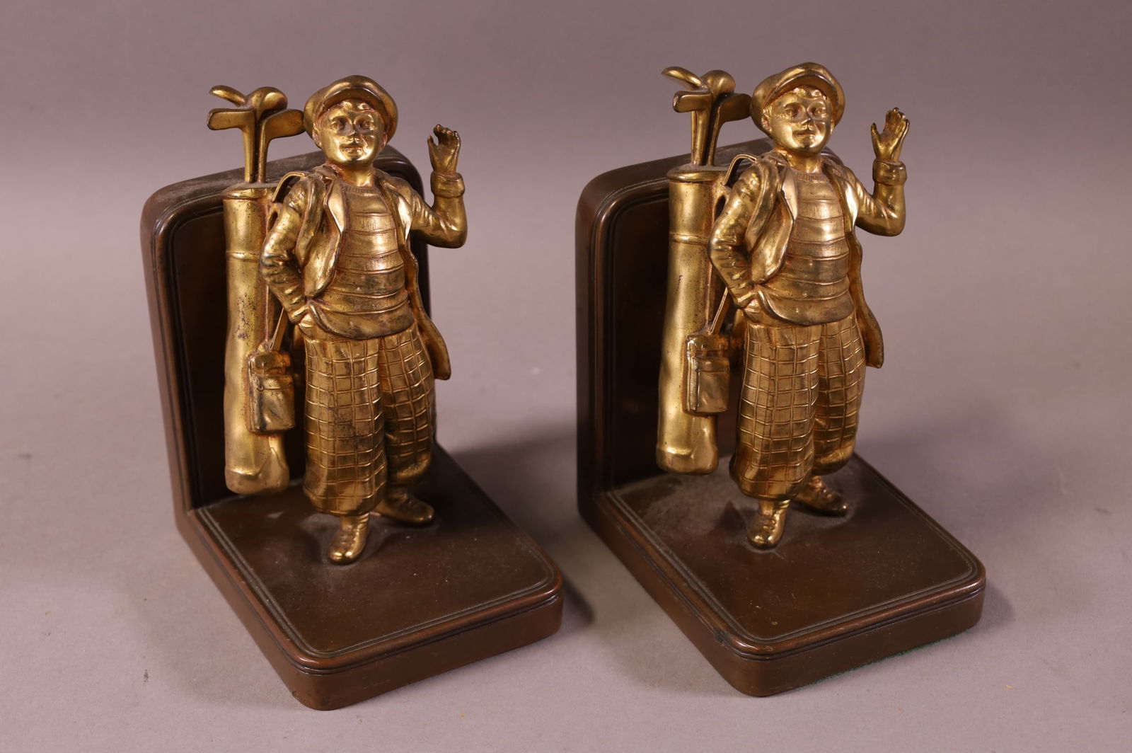 PAIR OF ANTIQUE GOLF CADDY CAST METAL BOOKENDS: CADDY FIGURE BOOKENDS. CRACK TO ONE. 6" H.