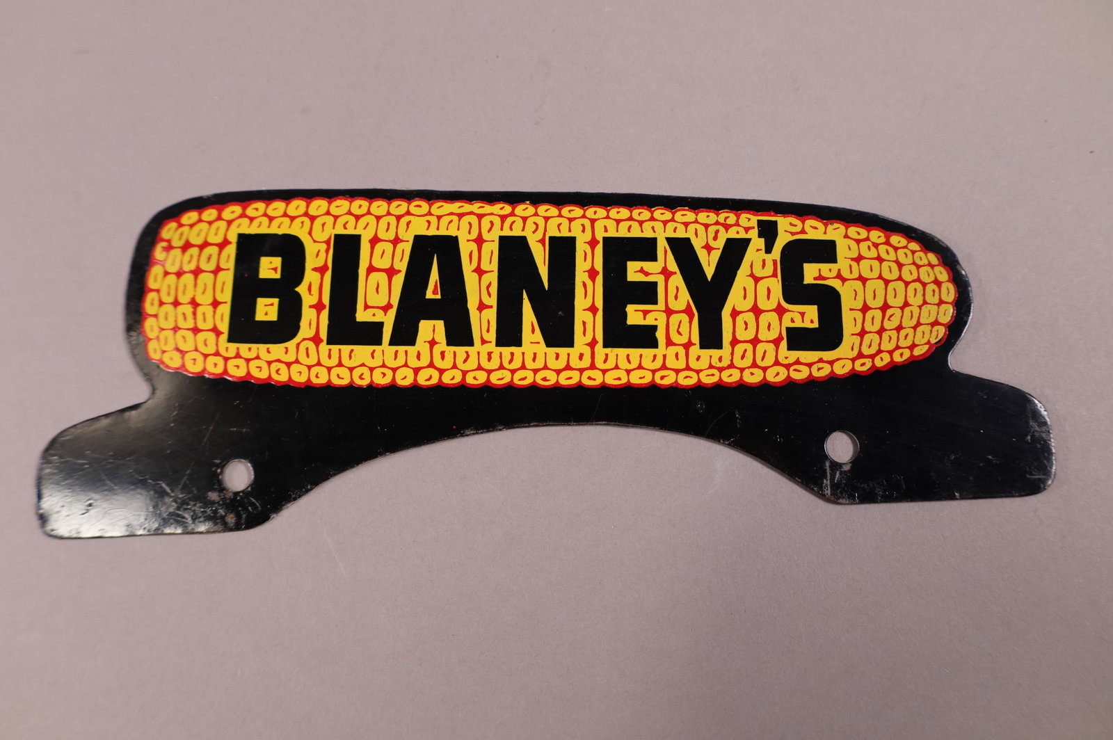 BLANEY'S TIN LICENSE PLATE TOPPER: BLANEY'S CORN TIN LICENSE PLATE TOPPER. LIGHT SURFACE SCRATCHES. 10" W x 3 1/2" H