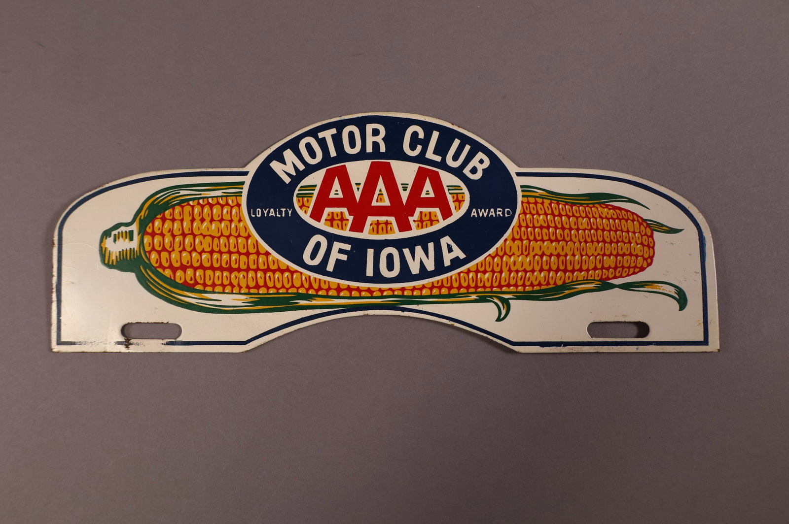 AAA MOTOR CLUB OF IOWA TIN LICENSE PLATE TOPPER: AAA MOTOR CLUB OF IOWA LOYALTY AWARD TIN LICENSE PLATE TOPPER. LIGHT SURFACE SCRATCHES. 11 1/8" W x 4" H