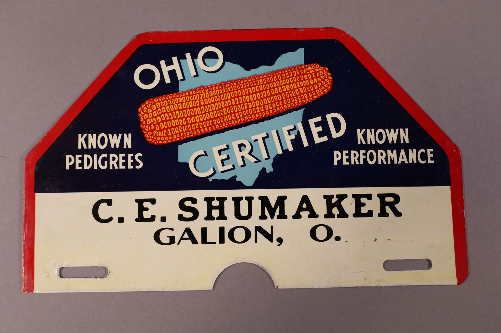 OHIO CERTIFIED TIN LICENSE PLATE TOPPER: C.E. SHUMAKER GALION, OH. OHIO CERTIFIED, KNOWN PEDIGREES, KNOWN PERFORMANCE TIN LCIENSE PLATE TOPPER. LIGHT SURFACE SCRATCHES. 10" W x 6" H