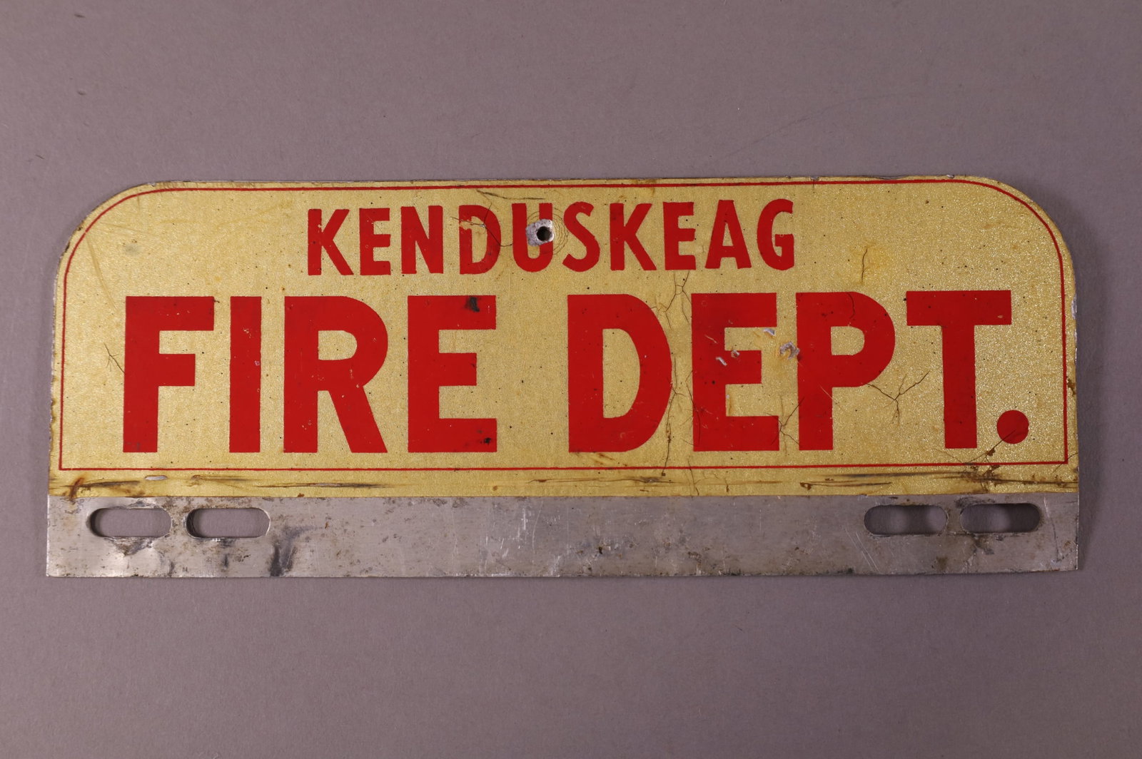 KENDUSKEAG FIRE DEPT TIN LICENSE PLATE TOPPER: KENDUSKEAG FIRE DEPARTMENT TIN LICENSE PLATE TOPPER. SURFACE SCRATCHES. 10" W x 3 3/4" H
