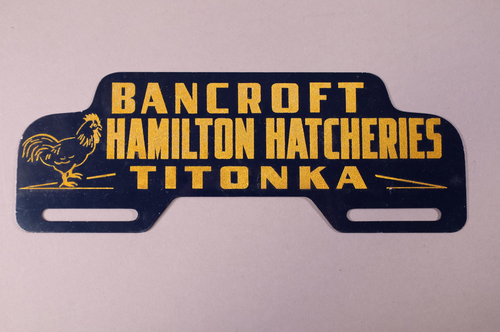 HAMILTON HATCHERIES TIN LICENSE PLATE TOPPER: HAMILTON HATCHERIES BANCROFT TITONKA TIN LICENSE PLATE TOPPER. GOOD CONDITION. 11" W x 3 3/4" H