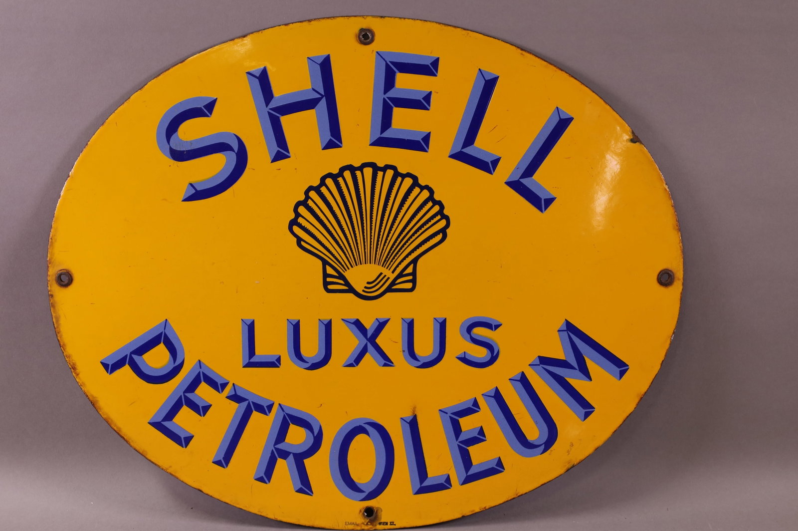 Shell Luxus Petroleum w/Logo Porcelain Sign (TAC): rated 9, 15.75"x19.5", SSP oval sign has very good color and gloss, very tiny check mark above the "L", marked Email ?. TAC #044203