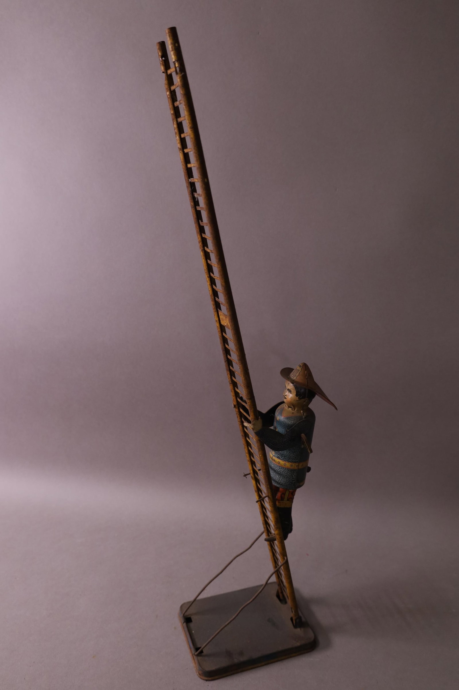 LOUIS MARX WIND UP FIREMAN: LOUIS MARX TIN LITHO FIREMAN ON LADDER. RUST & PITTING, MISSING TOP OF LADDER. 22" H
