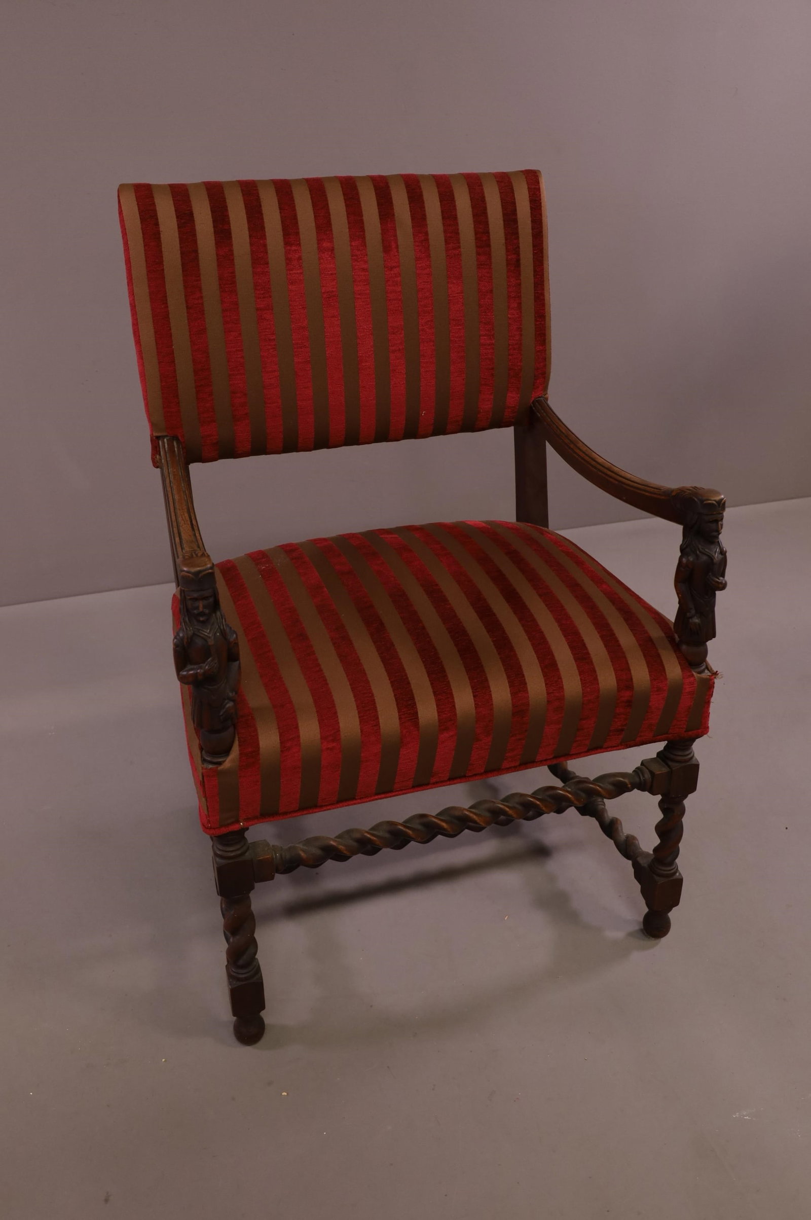1900'S FIGURAL CARVED HALL CHAIR: STRIPED UPHOLSTERY, FIGURAL CARVED ARMS. MINOR WEAR TO FINISH. 25" W x 19" D x 38" H. THIS ITEM EXCEEDS SIZE LIMITATIONS FOR IN HOUSE SHIPPING.