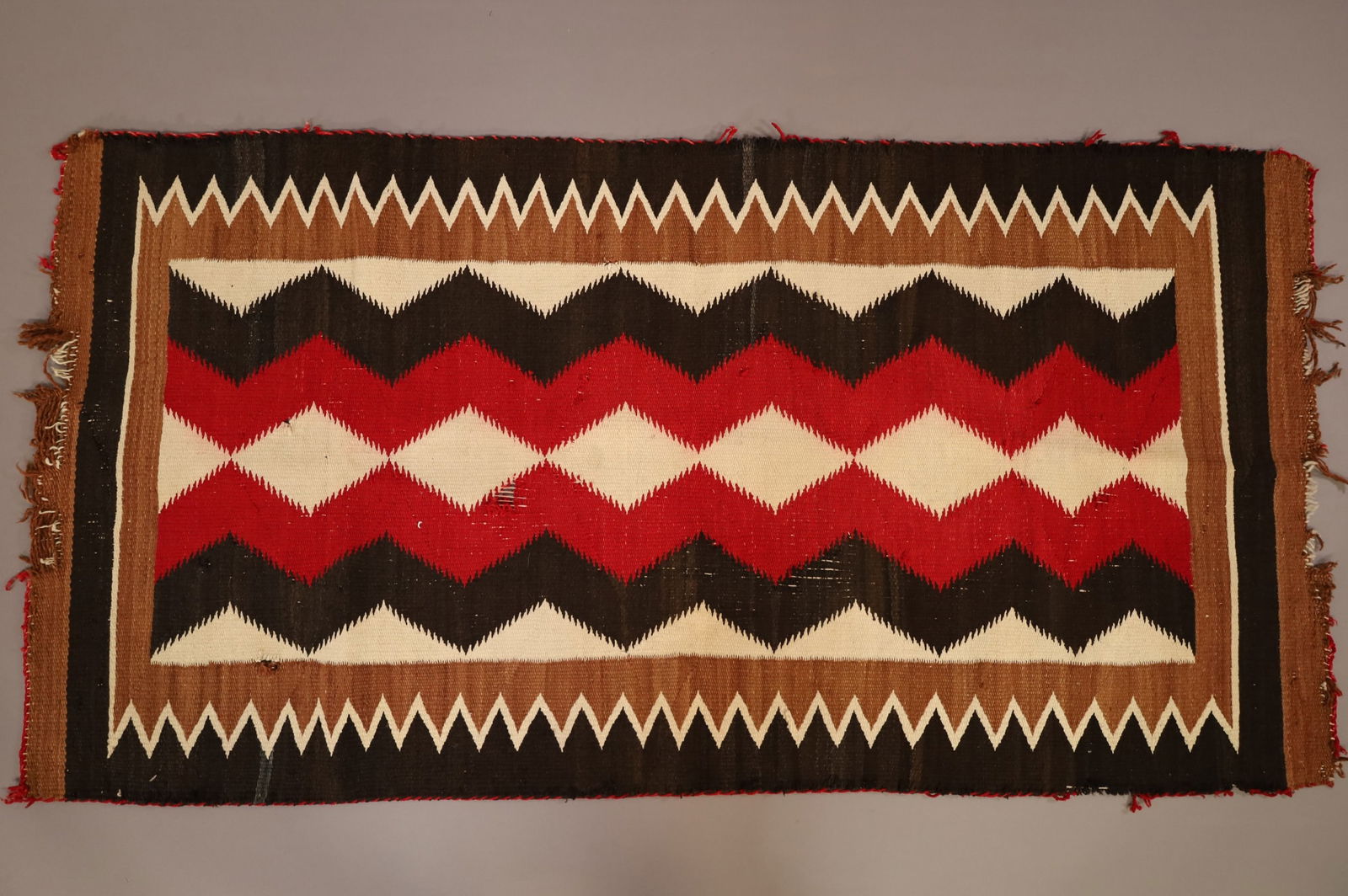 NATIVE AMERICAN NAVAJO RUG: 64" x 33" HANDMADE NAVAJO WEAVING, EDGE WEAR, MOTH DAMAGE.