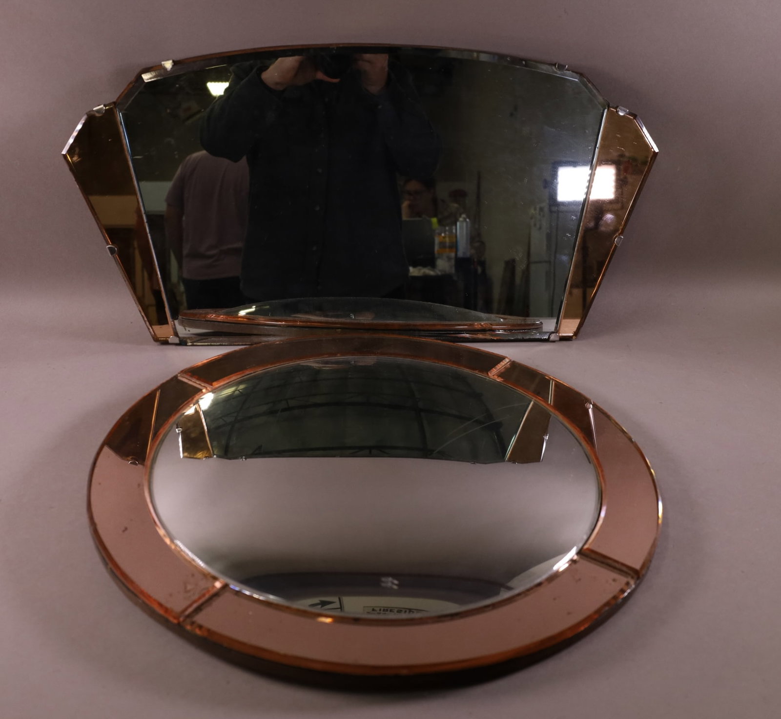 2 AMBER DECO WALL MIRRORS: AMBER DECO WALL MIRRORS, BOTH HAVE DAMAGE BULLEYES IS 20" DIAMATER, OTHER IS 25 1/2" W