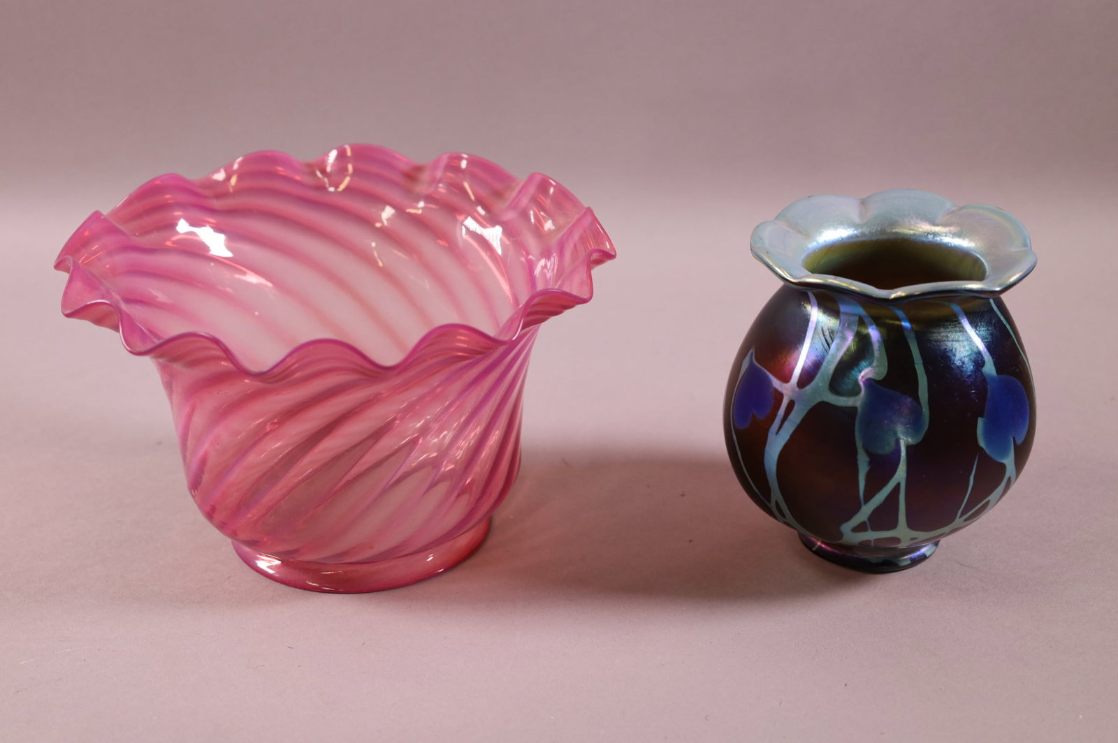 2 ART GLASS LAMP SHADES: CRANBERRY GLASS & CARL RADKE PHOENIX GLASS. SMALLER HAS 2" FITTER & 4 1/2" TALL. CRANBERRY IS 4" FITTER & 5" TALL.