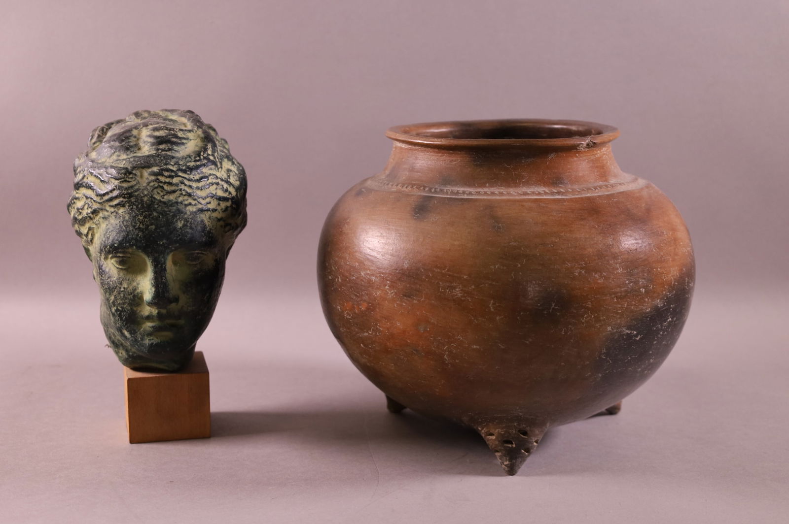 FOOTED CLAY POT & GRECIAN HEAD: POT HAS CHIP. POT IS 8" TALL. HEAD IS 8 1/2" TALL.