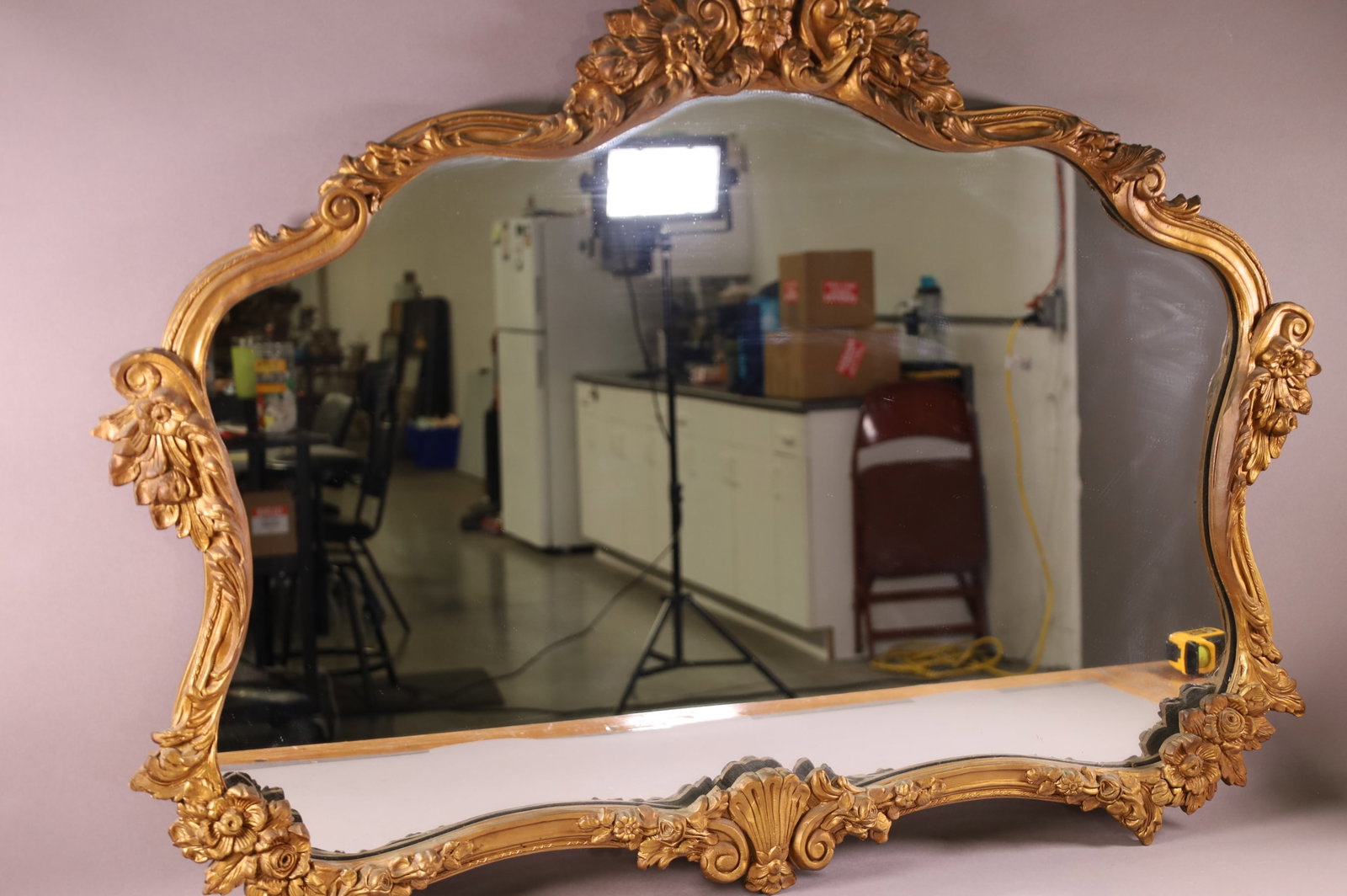 GOLD GILT WALL MIRROR: FLORAL DECORATED GOLD GILT WALL MIRROR. HAS SOME DAMAGE. 41" x 32" THIS ITEM EXCEEDS SIZE LIMITATIONS FOR IN HOUSE SHIPPING.