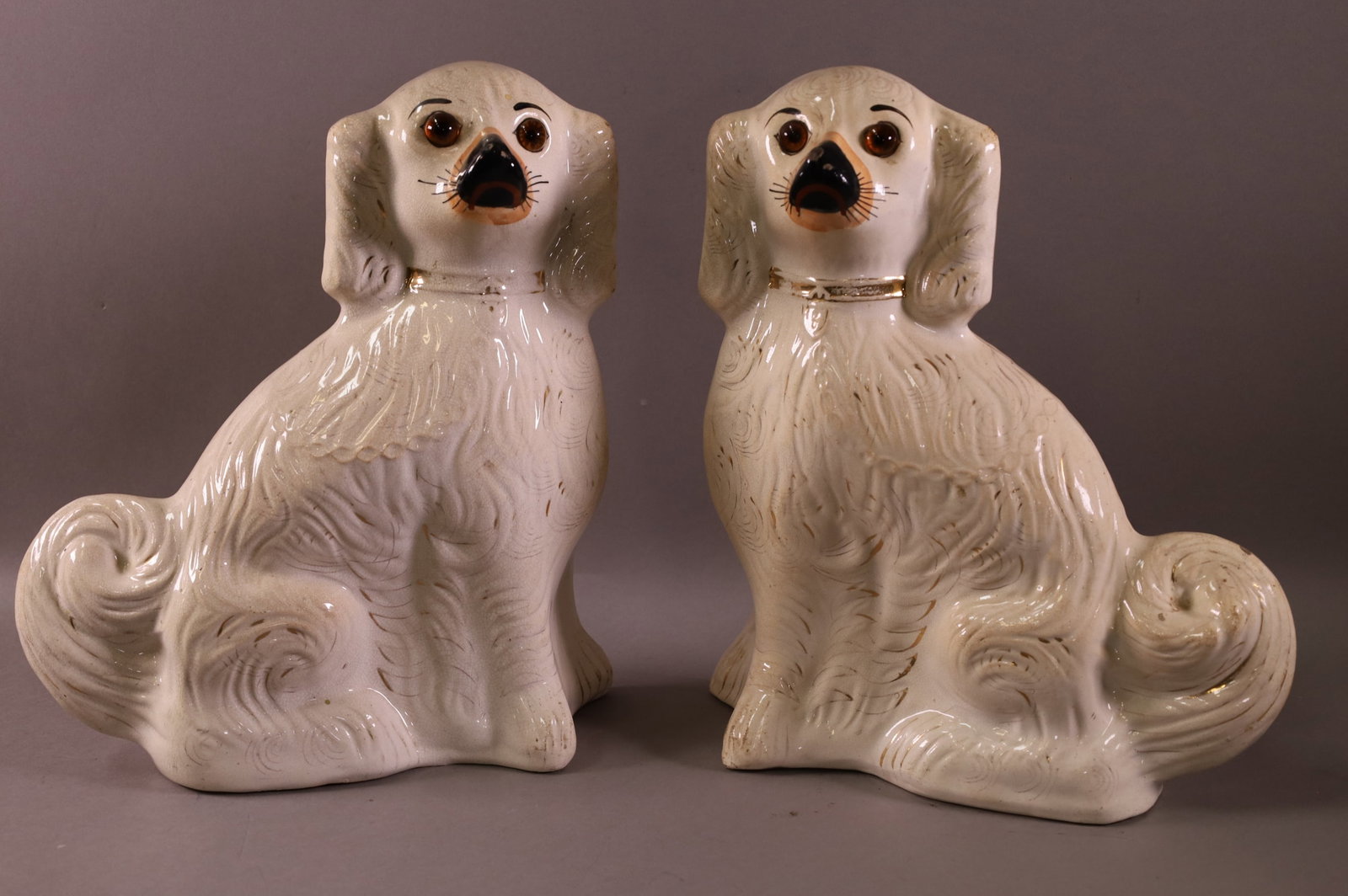 PAIR OF LARGE STAFFORDSHIRE DOGS: PAIR OF WHITE SPANIARD STAFFORDSHIRE DOGS WITH GLASS EYES. MINOR PAINT LOSS. 13 1/2" TALL.