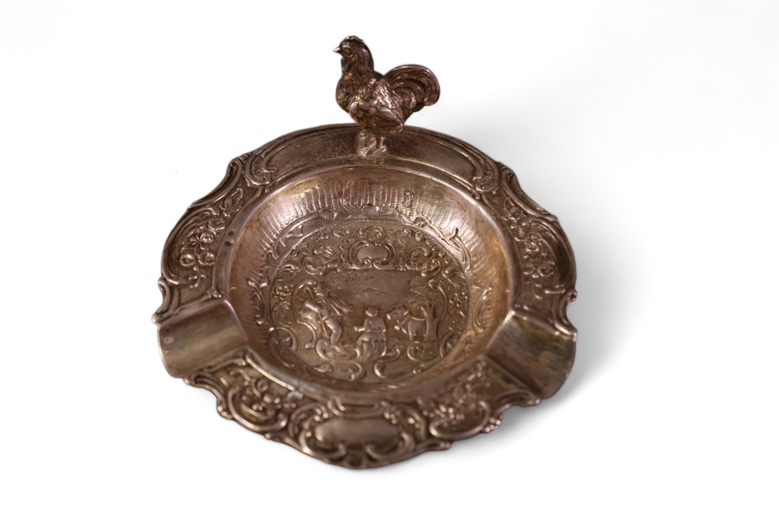 800 SILVER ASHTRAY WITH CHICKEN DECORATION: MAREKD ROBERT ANSTEAD LOS ANGELES. MARKED 800 SILVER. APPROX 134 GRAMS. 5" W.