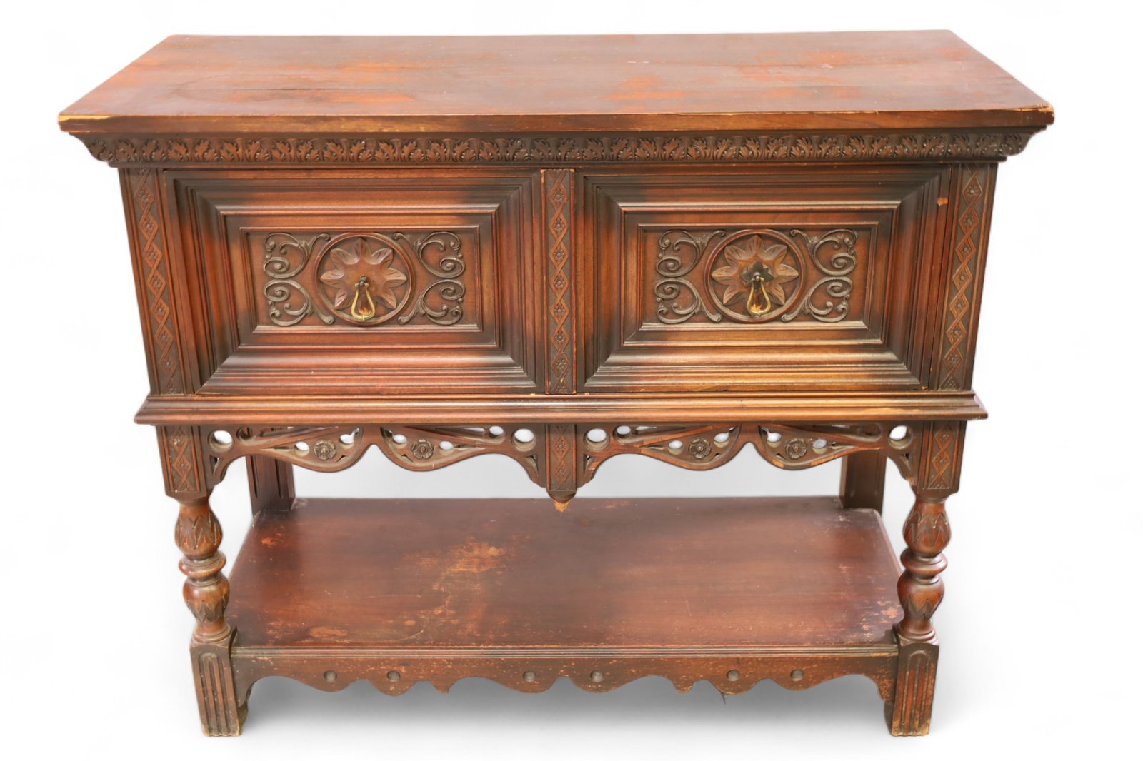 1920'S GOTHIC STYLE SERVER: ANTIQUE TWO DOOR SERVER, GOTHIC STYLE, VENEER DAMAGE, WEAR TO FINISH. CHIPS TO CORNERS. 42" W x 18" D x 34" H. THIS ITEM EXCEEDS SIZE LIMITATIONS FOR IN HOUSE SHIPPING, IT MUST BE PICKED UP IN HOUSE O