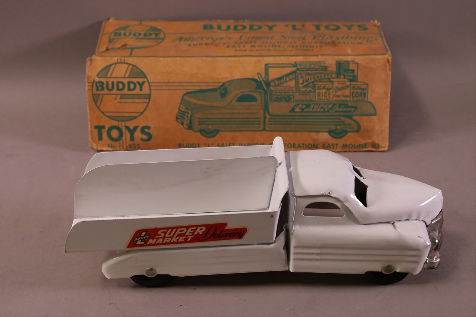 BUDDY L TOYS STEEL TRUCK: BUDDY L NO.325 SUPERMARKET DELIVERY TRUCK IN BOX. BOX HAS DAMAGE, LIGHT SCRATCHES TO PAINT ON TRUCK. 13"L