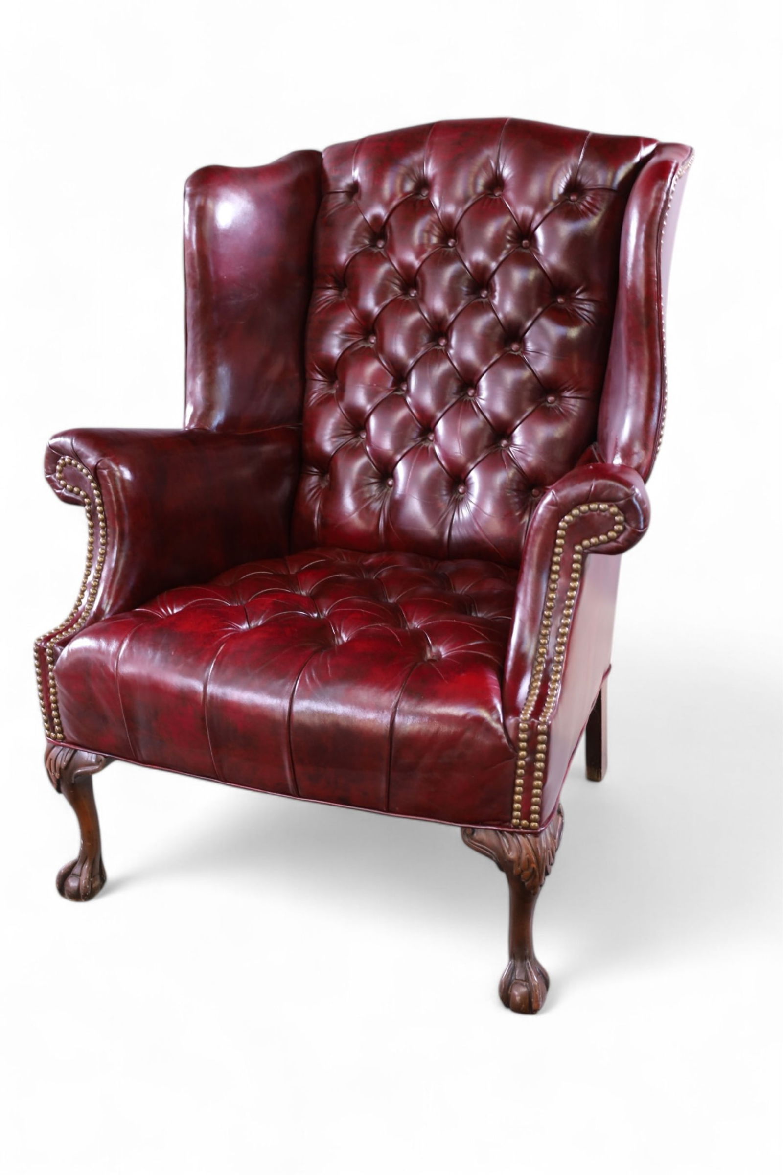 CHESTERFIELD STYLE WING CHAIR: TALL WIING BACK LEATHERETTE CHESTERFIELD STYLE CHAIR. BRASS TACKED. MINOR WEAR TO UPHOLSTERY. 29" W x 26" D x 40" H. THIS ITEM EXCEEDS SIZE LIMITATIONS FOR IN HOUSE SHIPPING, MUST BE PICKED UP HOUSE O