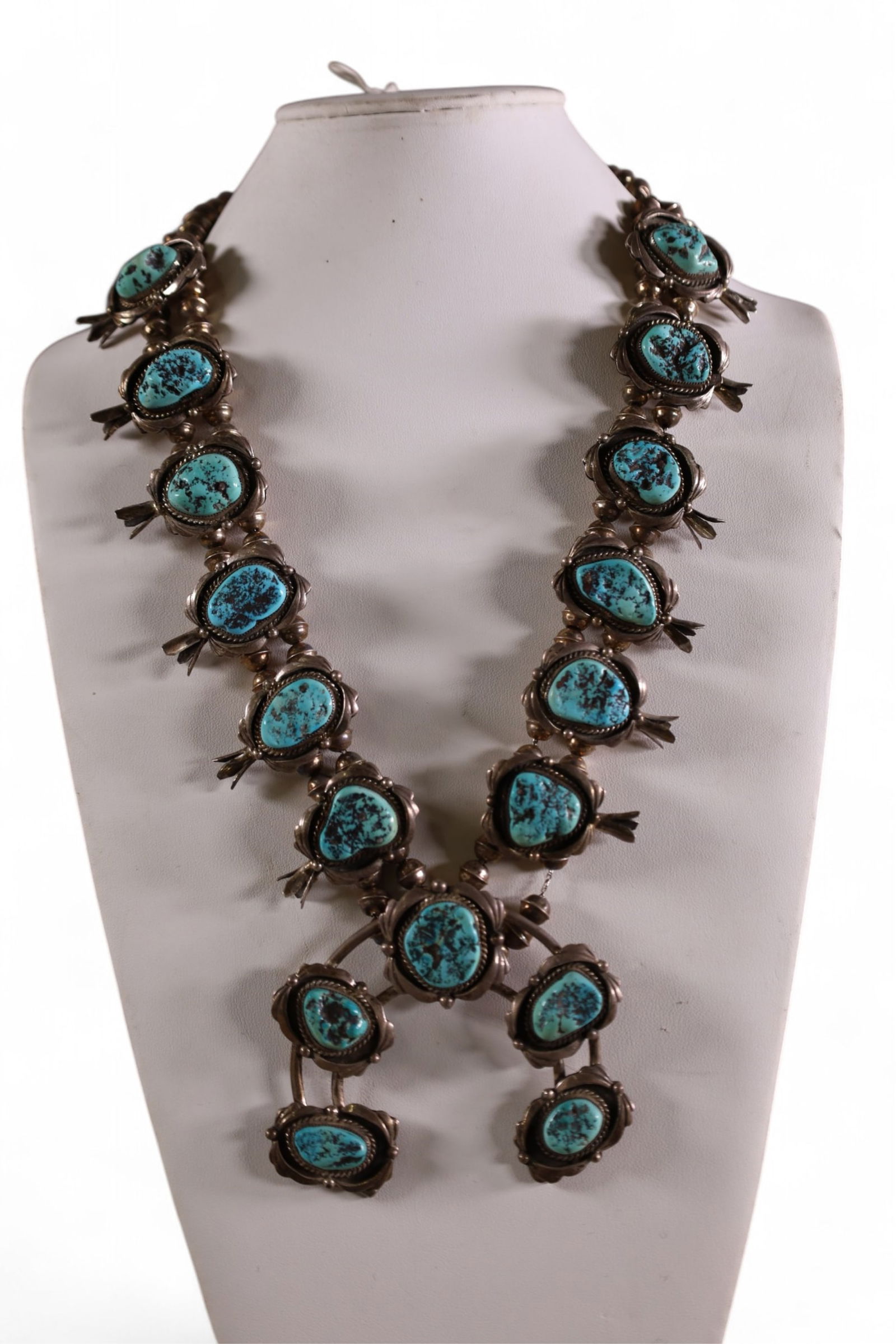 STERLING SILVER & TURQUOISE SQUASH BLOSSOM: HANDMADE NATIVE AMERICAN STERLING SILVER AND TURQUOISE SQUASH BLOSSOM NECKLACE. ROPE TWIST. UNMARKED, UNSIGNED. 16" L. APPROX 268 GRAMS TOTAL WEIGHT.