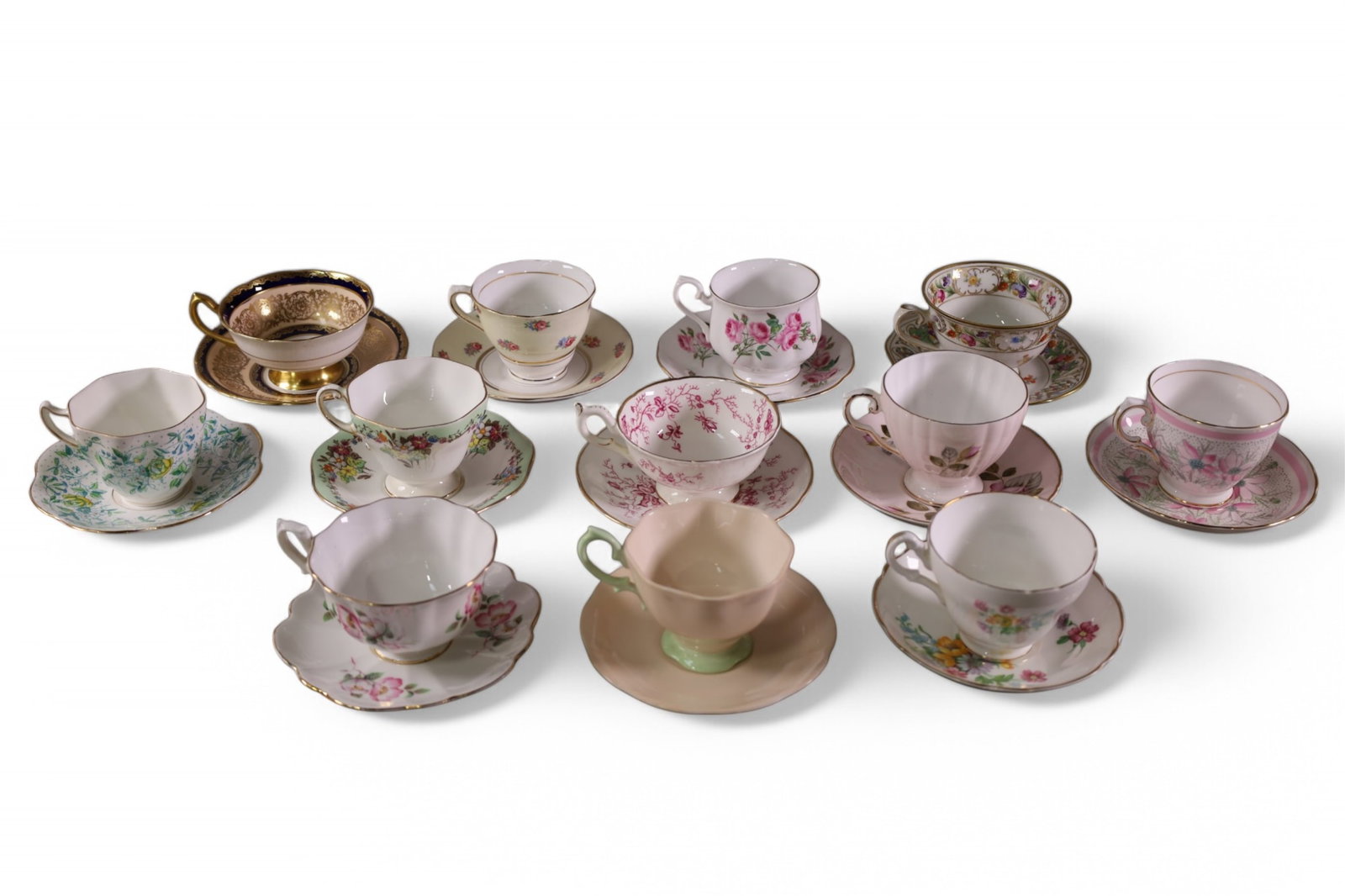 COLLECTION OF 12 CUPS & SAUCERS: INCLUDING ROYAL ALBERT, SCHUMANN, SHELLEY, AND MORE.