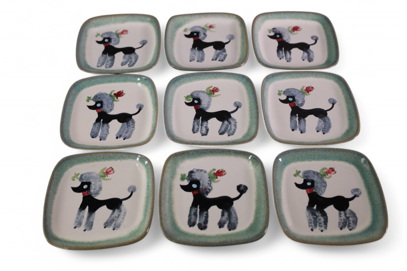 9 GLIDDEN PLATES: SET OF 9, SIGNED GLIDDEN PLATES. POTTERY POODLE PLATES. 5 1/2" x 5 1/2"