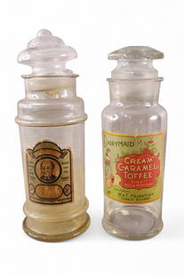 2 APOTHECARY JARS: DAIRYMAID LIDDED APOTHECARY JAR CREAM CARAMEL TOFFEE & BUCHANAN LOZENGES. 13" & 15" H.