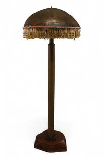 TRENCH ART FLOOR LAMP: WOODEN PROP BASE, WITH LARGE SPENT SHELL POST & PUNCHED COPPER SHADE. 22" DIAM SHADE & 64" H. THIS ITEM EXCEEDS SIZE OR WEIGHT LIMITATIONS FOR IN HOUSE SHIPPING, MUST BE PICKED UP VIA 3rd PARTY GROUND