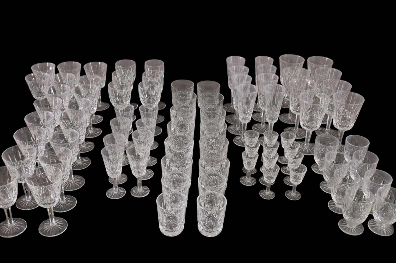 LARGE COLLECTION OF WATERFORD CRYSTAL: 83 PIECES OF WATERFORD LISMORE CRYSTAL. INCLUDING WINE GLASSES, CORDIALS, GOBLETS,SCOTCH GLASSES, ROCKS GLASSES, AND MORE. SOME FLEA BITE CHIPS.