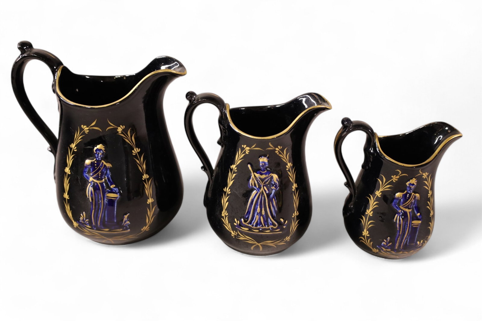 3 PIECES OF QUEEN VICTORIA PORCELAIN: 3 PITCHERS, QUEEN VICTORIA AND PRINCE ALBERT, BLACK GLAZED PITCHERS. 6" - 8" H.