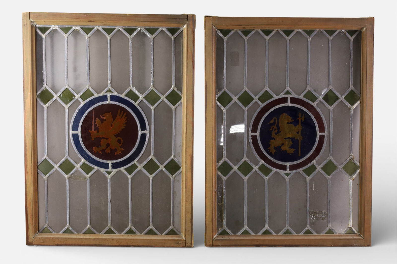 PAIR OF STAINED GLASS WINDOWS: PAIR OF FRAMED STAINED GLASS, WINDOWS, LION CREST CENTER, SOME CRACKED PANELS. 18" x 25"