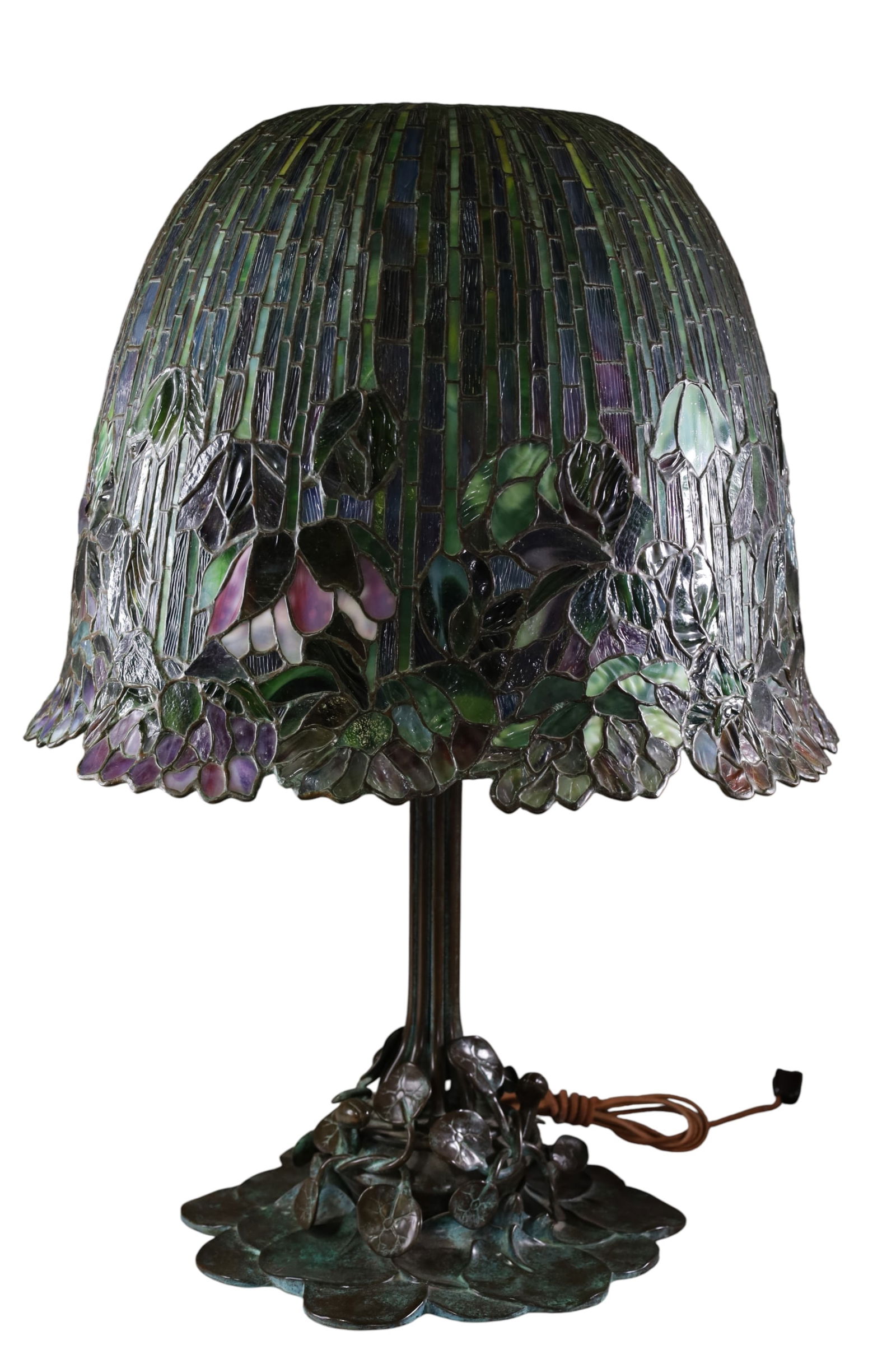 BUFFALO STUDIOS BRONZE TABLE LAMP: LARGE BUFFALO STUDIOS BUFFALO METAL WORKS LEADED GLASS TABLE LAMP, LARGE LILY PAD BRONZE BASE No. 4, & FLORAL LEADED SHADE, BOTH SHADE & BASE ARE MARKED. 10 LIGHT LAMP. 19" DIAM SHADE & 14 1/2" H.