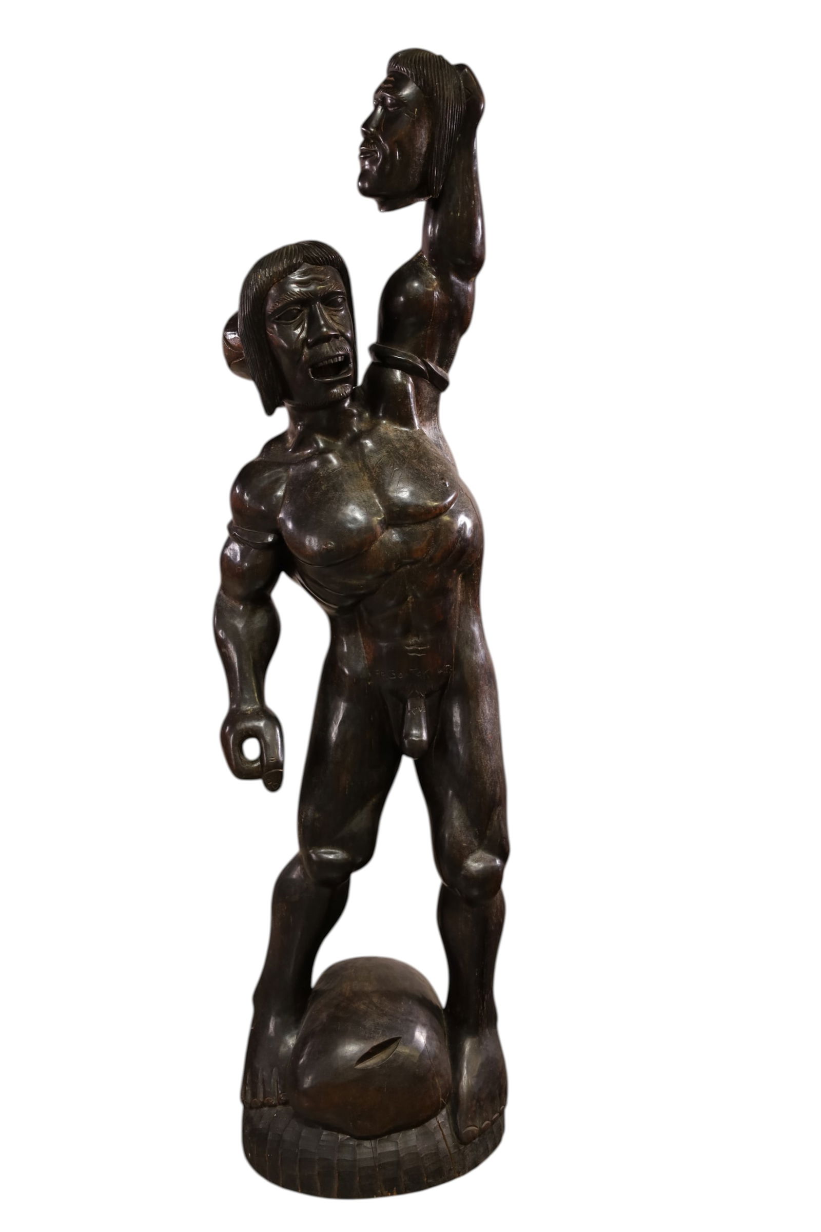 TALL CARVED WOODEN SCULPTURE: AFRICAN HEAD HUNTER CARVED WOOD SCULPTURE. EROTIC HEAD HUNTER SCULPTURE, 59" H. THIS ITEM EXCEEDS SIZE LIMITATIONS FOR IN HOUSE SHIPPING, MUST BE PICKED UP IN HOUSE OR SHIPPED VIA 3rd PARTY GROUND