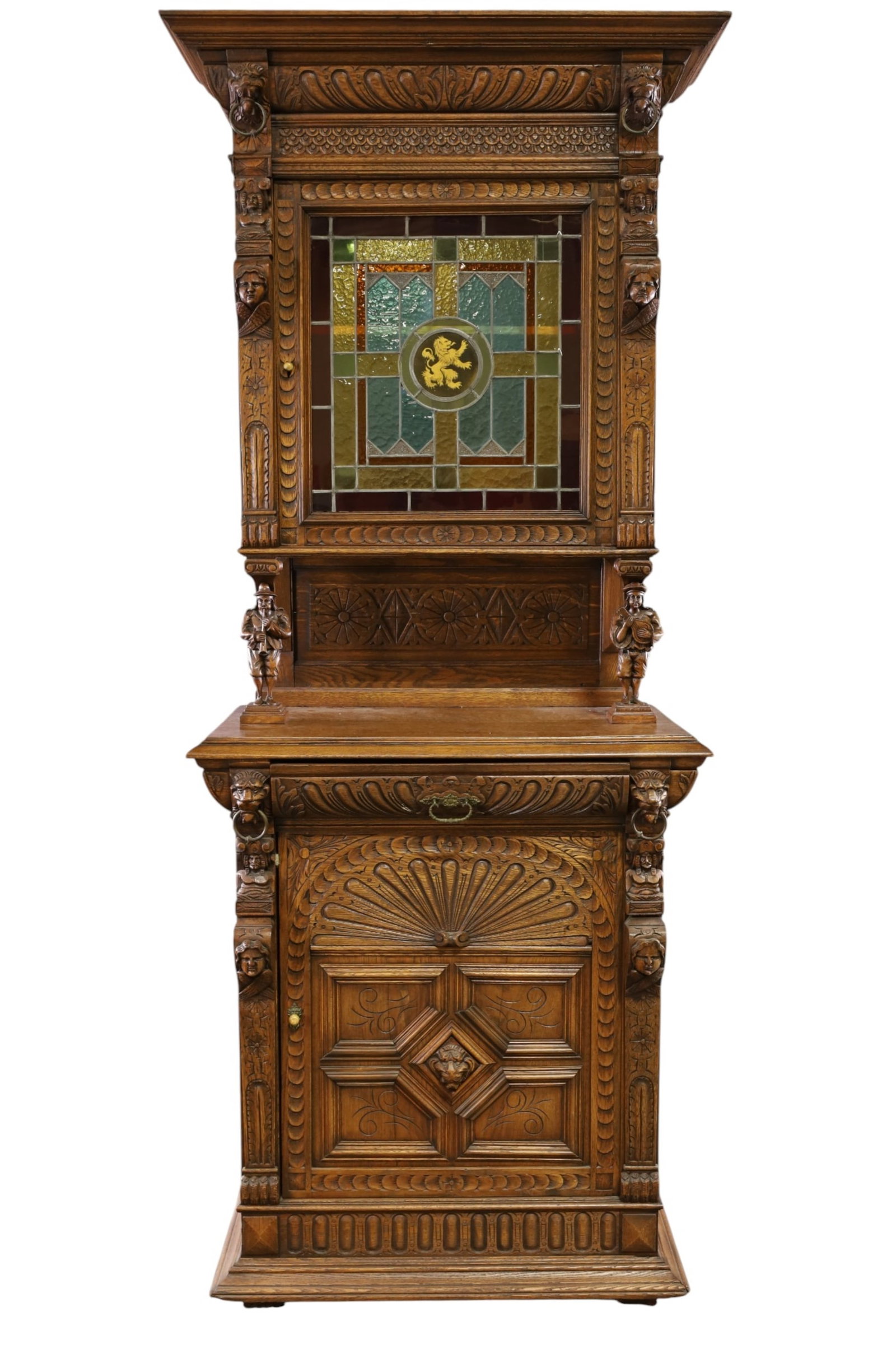19TH CENTURY NARROW OAK CABINET: 2 PIECE FLEMISH OAK HALL CABINET, WITH STAINED GLASS UPPER DOOR. FIGURAL WITH LOWER DRAWER AND DOOR. 35" W x 19 1/2" D x 90" H. THIS ITEM EXCEEDS SIZE LIMITATIONS FOR IN HOUSE SHIPPING, MUST BE
