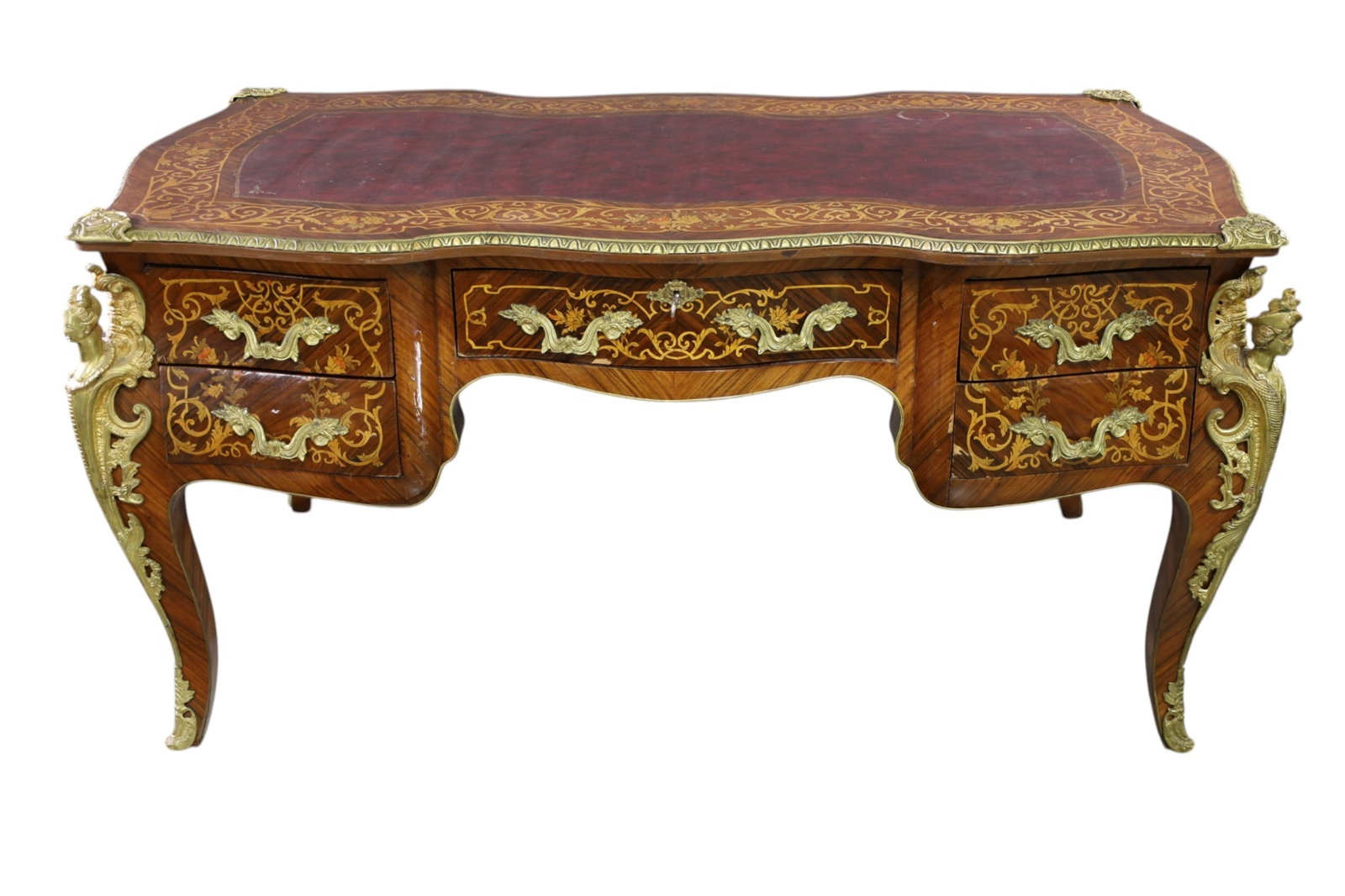 FRENCH STYLE DESK: BOMBAY LEATHER TOP, FRENCH STYLE BUREAU PLAT DESK, SOME BUBBLING IN VENEER. VENEER CHIPS. TOP IS LOOSE. 65" W x 35" D x 32" H. THIS ITEM EXCEEDS SIZE LIMITATIONS FOR IN HOUSE SHIPPING, MUST BE PICKED