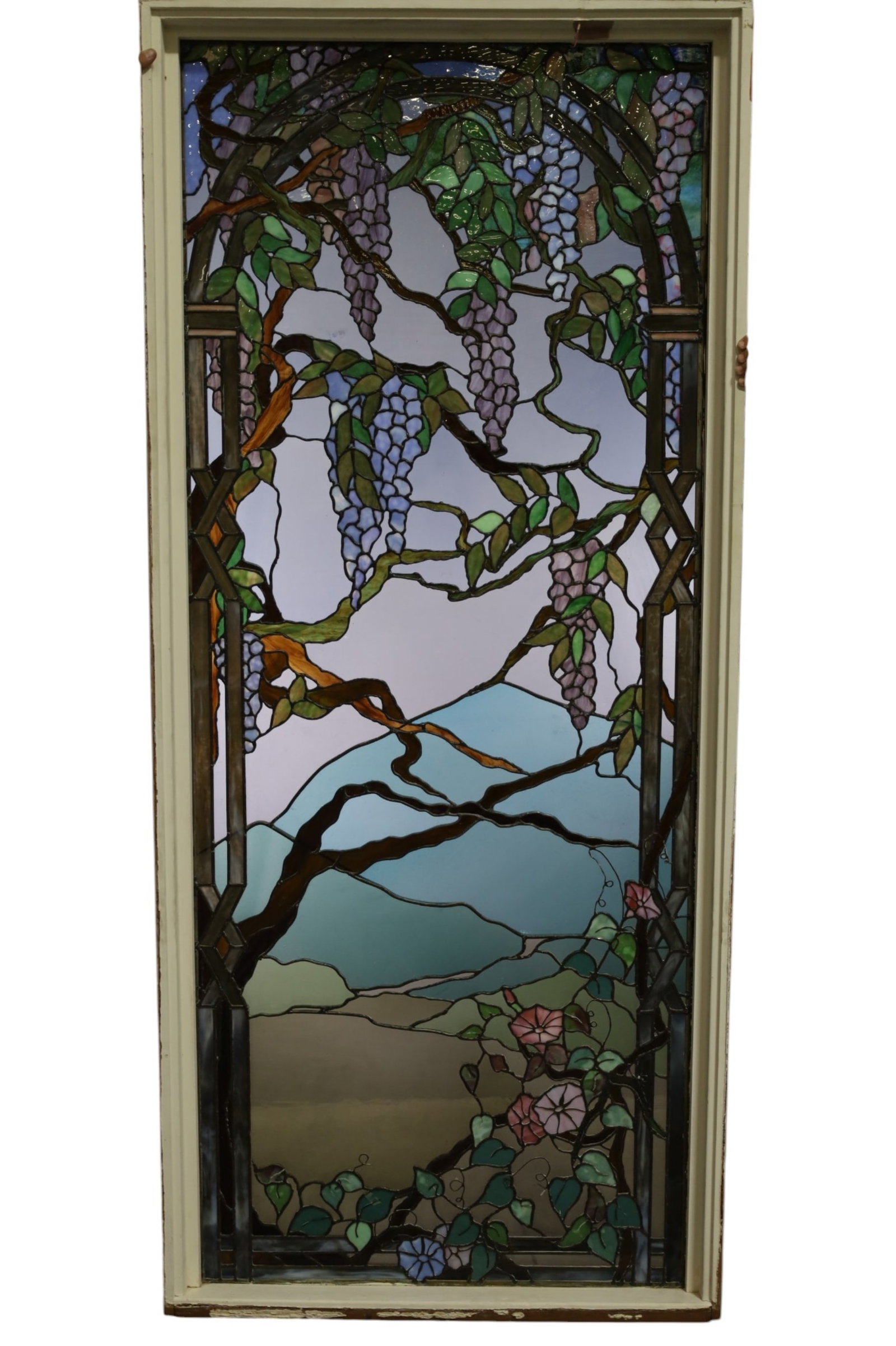 LARGE STAINED GLASS WINDOW: LARGE STAINED GLASS WINDOW, TIFFANY STYLE LEADED WINDOW IN FRAME, WISTERIA MOTIF. 81" H x 35 1/2" W. THIS ITEM EXCEEDS SIZE LIMITATIONS FOR IN HOUSE SHIPPING, MUST BE PICKED UP IN HOUSE OR SHIPPED