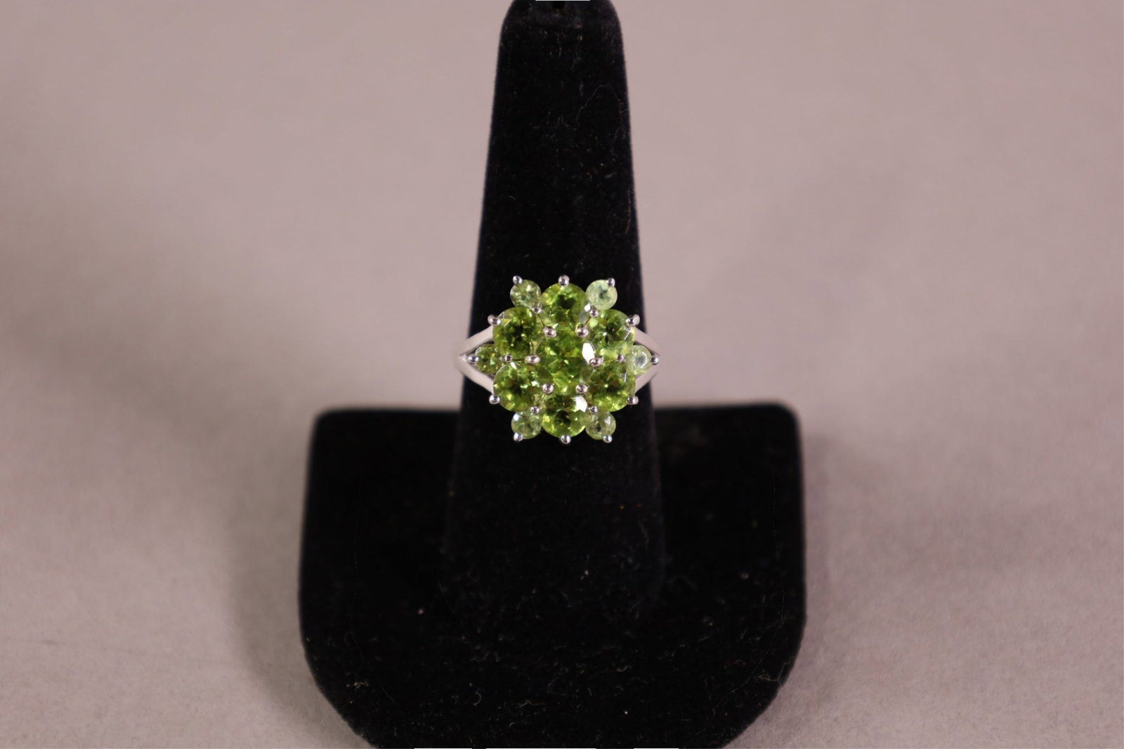 10K GOLD & PERIDOT RING: 10K WHITE GOLD, RING WITH 13 PERIDOTS. SIZE 8.5. APPROX 4 GRAMS.