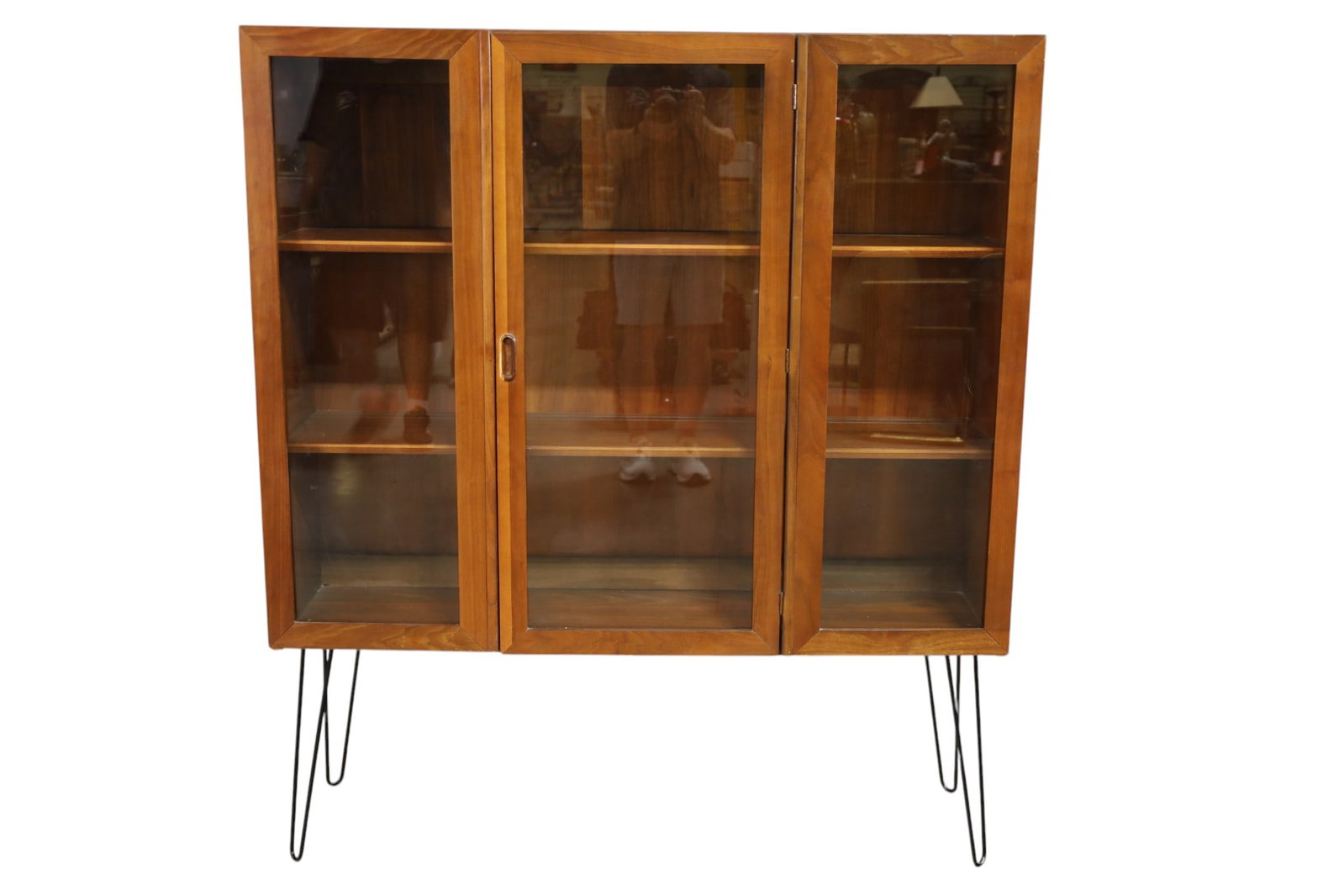 MID CENTURY MODERN HALL CABINET: THREE DOOR MID CENTURY MODERN HALL CABINET OR BOOKCASE, ADDED LEGS. INTERIOR SHELVES. DAMAGE TO HANDLE, MINOR VENEER DAMAGE. 50" W x 14" D x 58' H. THIS ITEM EXCEEDS SIZE LIMITATIONS FOR IN HOUSE