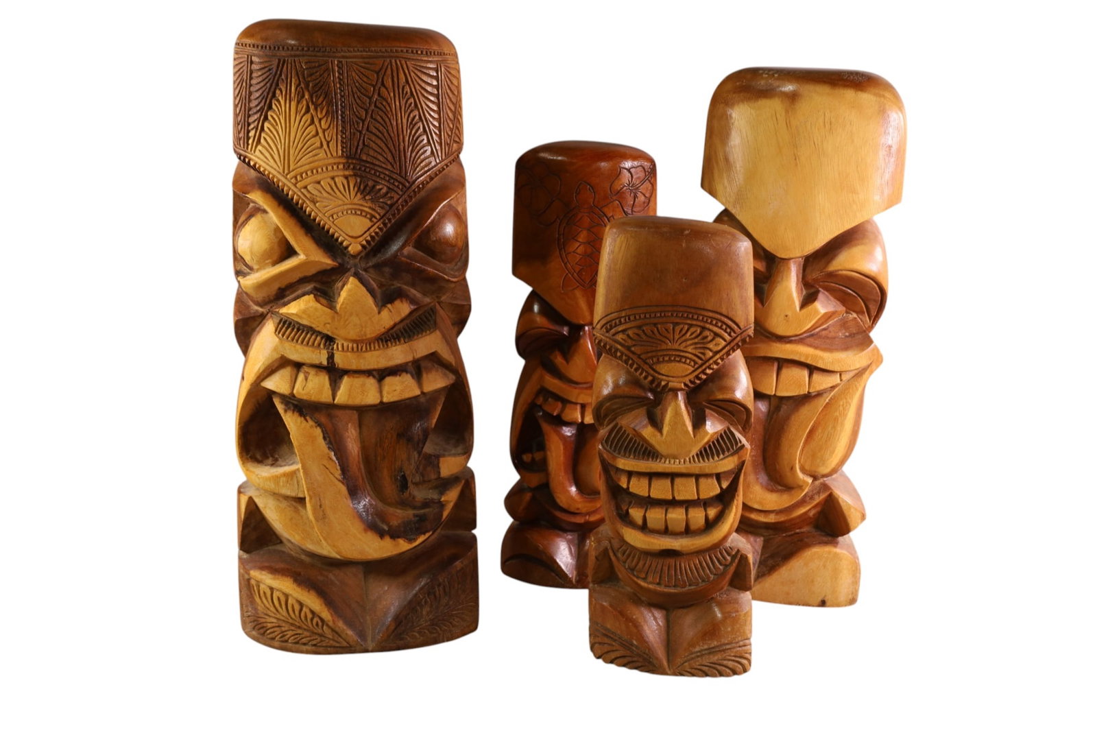 4 CARVED TIKIS: 4 SMALL CARVED WOODEN TIKIS, MAUI LAVAKA. 2006. 16" - 23" H.
