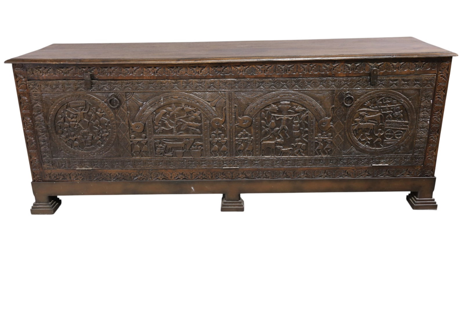 LARGE ASIAN TRUNK: LARGE HIGHLY CARVED FRONT ASIAN TRUNK, FLIP TOP LID AND DROP FRONT. INTERIOR SHELVES. IN CUSTOM IRON BASE. 77" W x 21" D x 30" H. THIS ITEM EXCEEDS SIZE LIMITATIONS FOR IN HOUSE SHIPPING, MUST BE