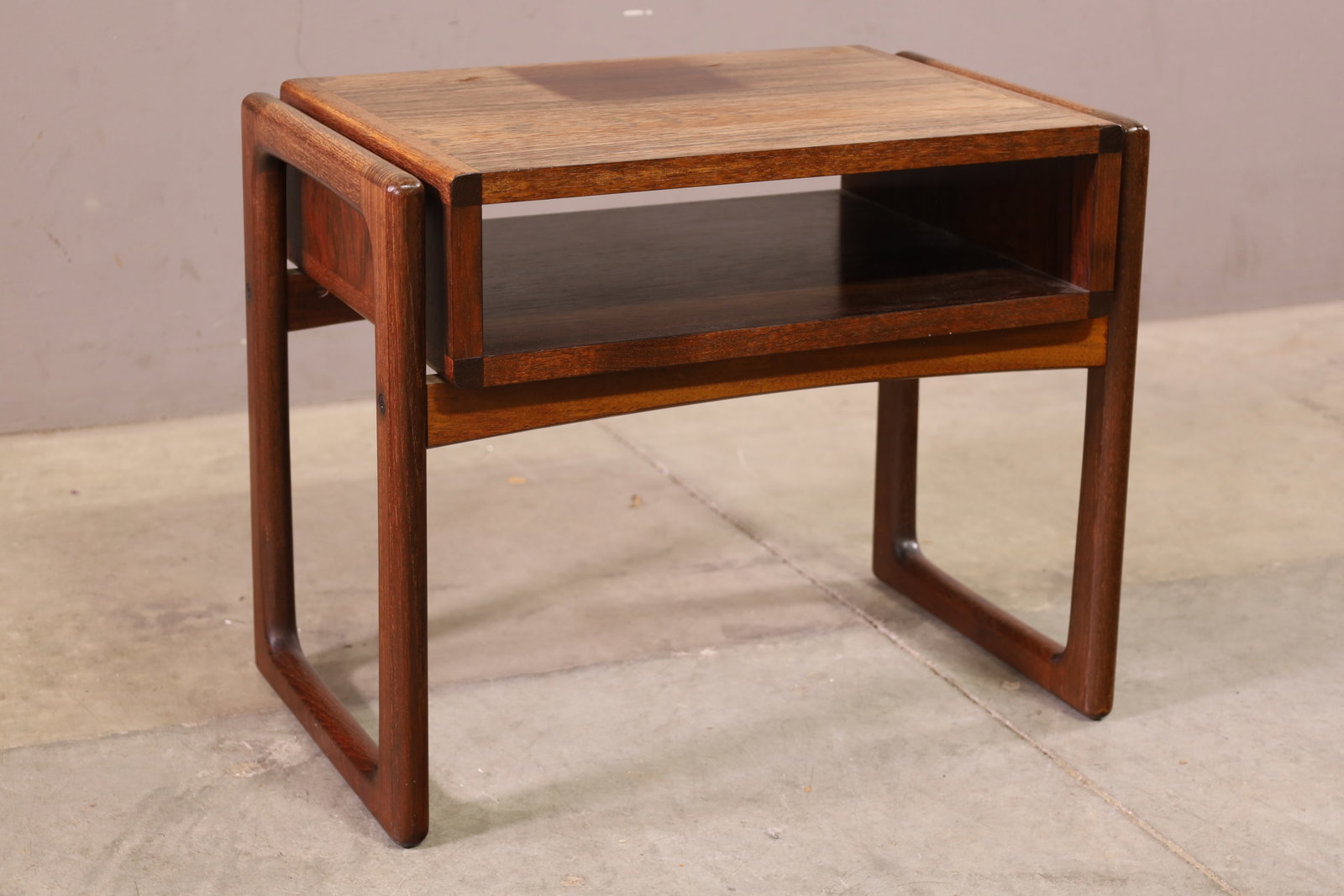 MID CENUTRY MODERN SIDE TABLE: MID CENTURY MODERN ROSEWOOD SIDE TABLE, STAIN TO TOP. FADED. TOP NEEDS REFINISHED. 21 1/2" W x 14" D x 18" H. THIS ITEM EXCEEDS SIZE LIMITATIONS FOR IN HOUSE SHIPPING, MUST BE SHIPPED VIA 3rd PARTY GR