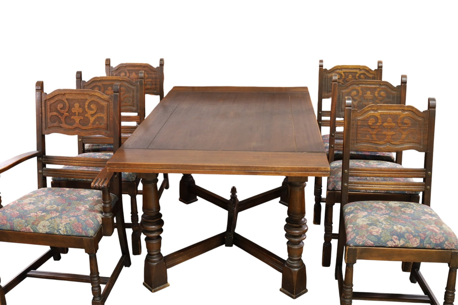 8 PC. 1930'S SPANISH STYLE DINING ROOM SET: DINING TABLE AND 6 CHAIRS, HIGHLY CARVED BUFFET. FLORAL UPHOLSTERY CHAIRS. CARVED BUFFET (TOP NEEDS REFINISHED) WEAR TO FINISH. TABLE 36" W x 60" W x 29" H. & 2 12" LEAVES. & BUFFET, 67" W x 20" D x
