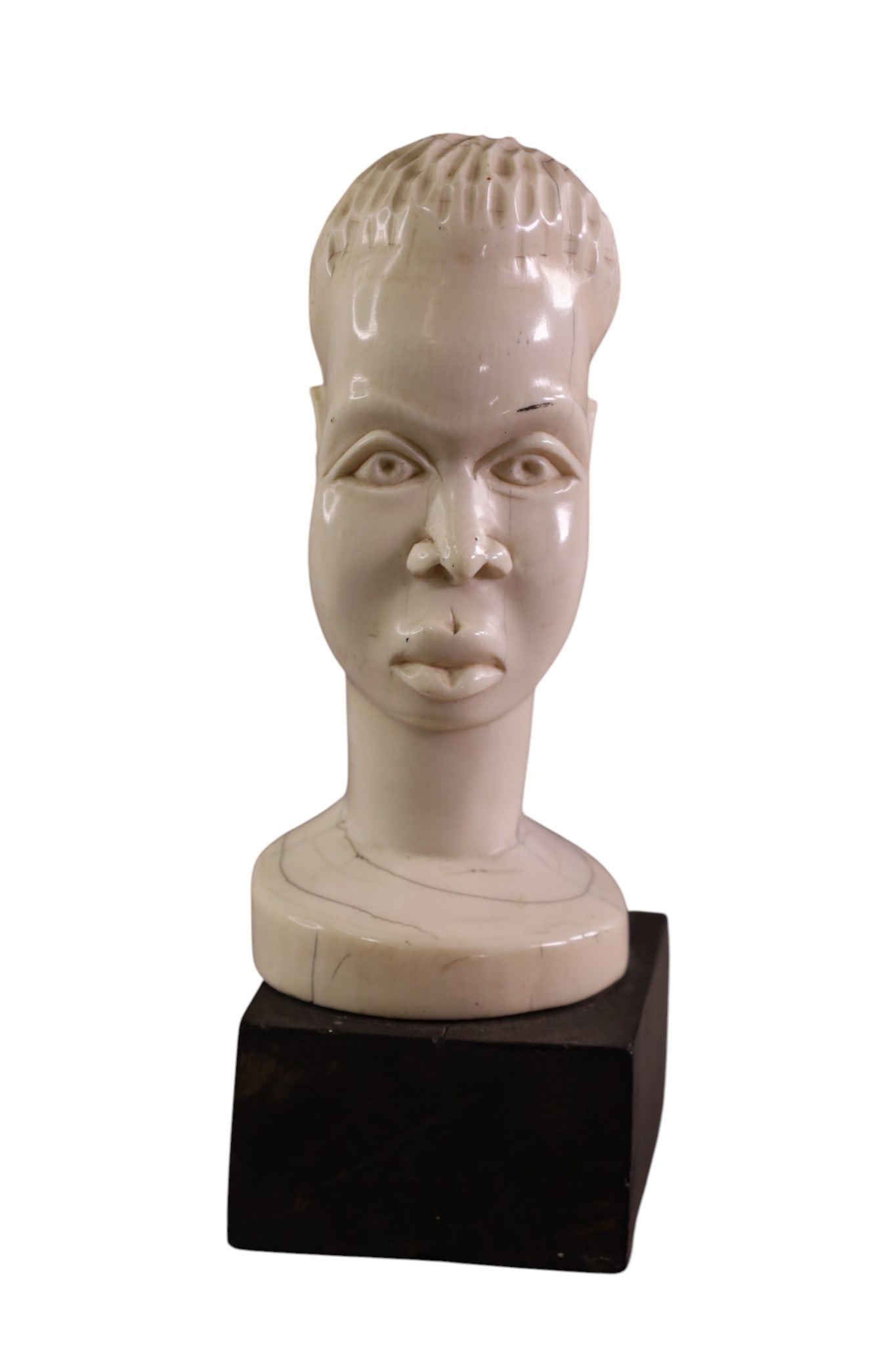 AFRICAN CARVED BUST: SMALL AFRICAN BONE CARVED FIGURE ON WOODEN BASE. SOME CRACKS/ 8" H.