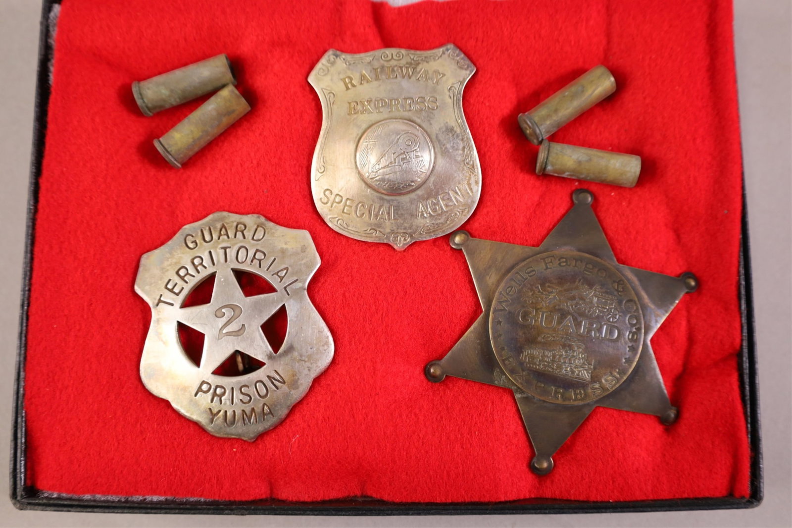 GROUPING OF OBSOLETE BADGES: WELLS FARGO, RAILWAY EXPRESS, & YUMA PRISON. OBSOLETE BADGES IN CASE.