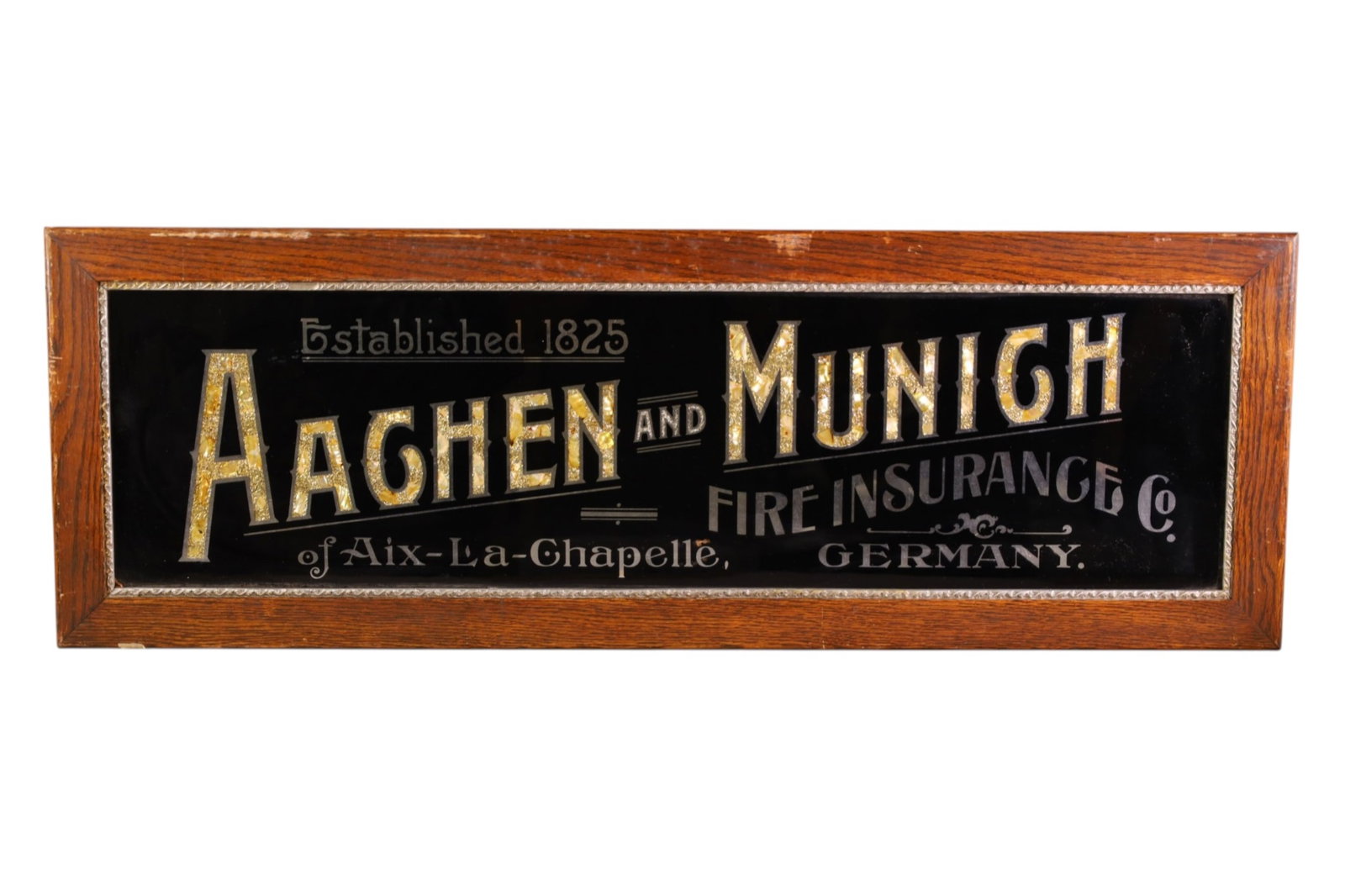 AAGHEN-MUNICH FIRE INSURANCE CO AD: AAGHEN MUNICH FIRE INSURANCE CO, GERMANY. MOTHER OF PEARL INLAY. IN OAK FRAME. 39 1/2" x 13 1/2"