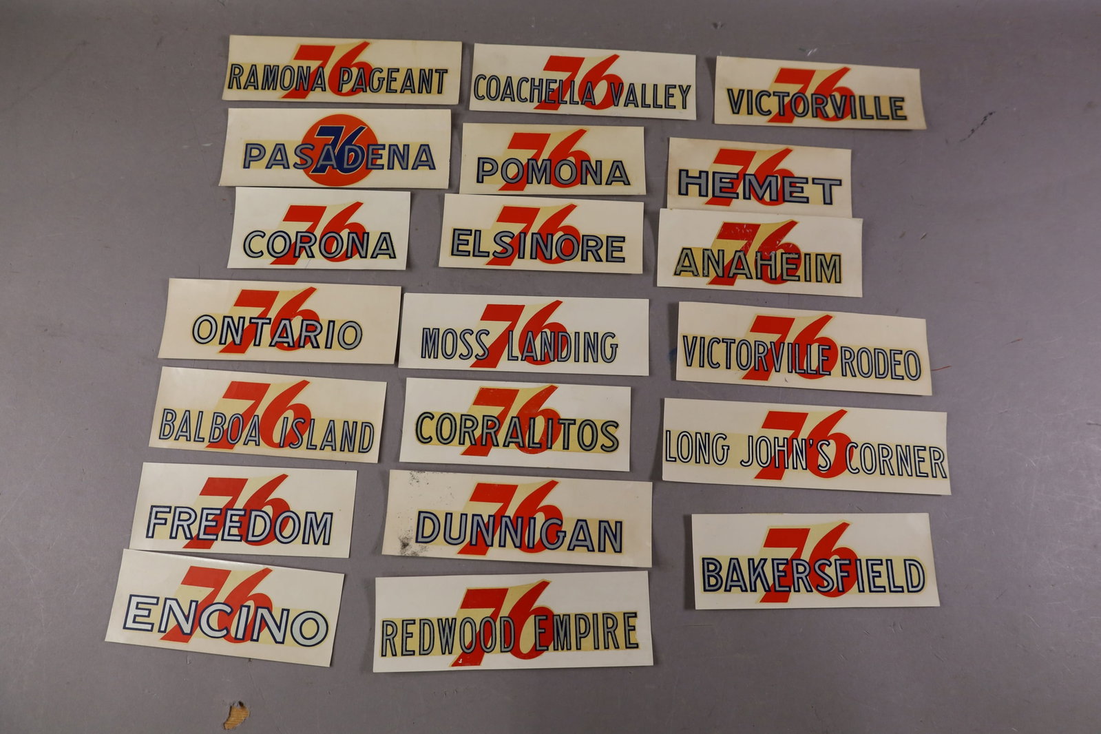 20 UNION 76 WATER TRANSFER DECALS: INCLUDING, PASADENA, POMONA, ELSINORE, AND MORE. EDGES ARE CURLED.
