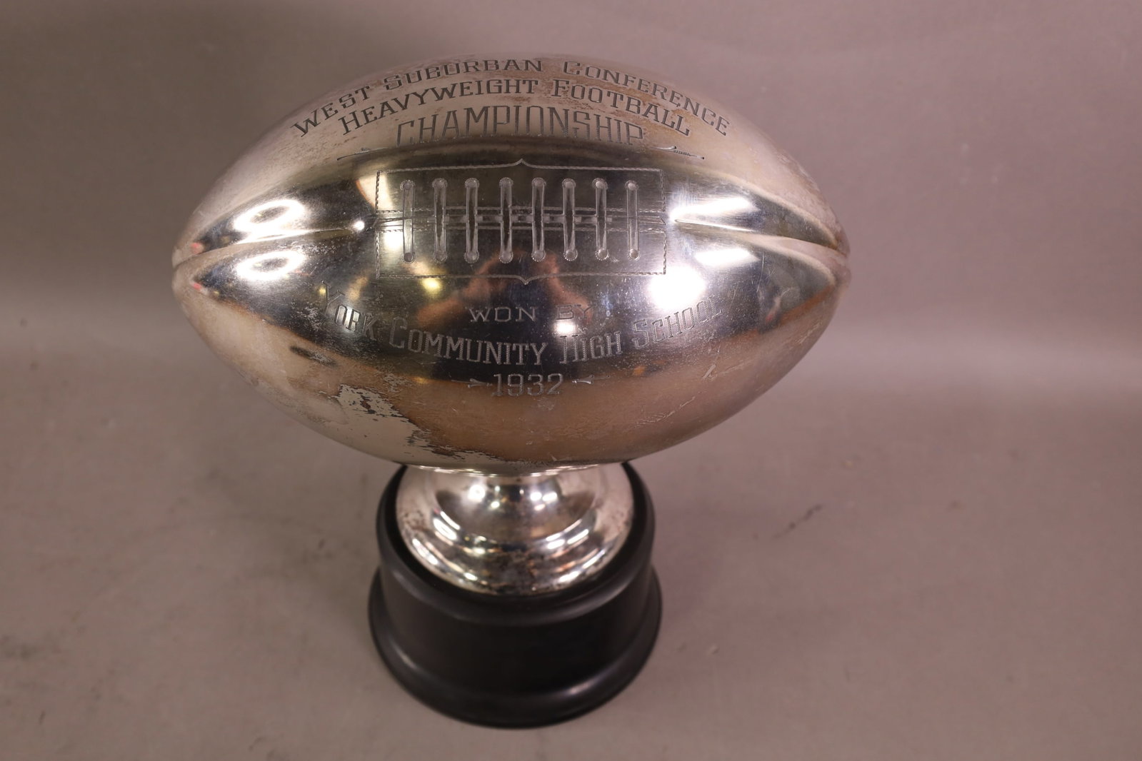 1932 FOOTBALL TROPHY: YORK COMMUNITY H.S. SILVERPLATED FOOTBALL TROPHY. SOME TARNISHING. DENTS. 11" W x 12" H.