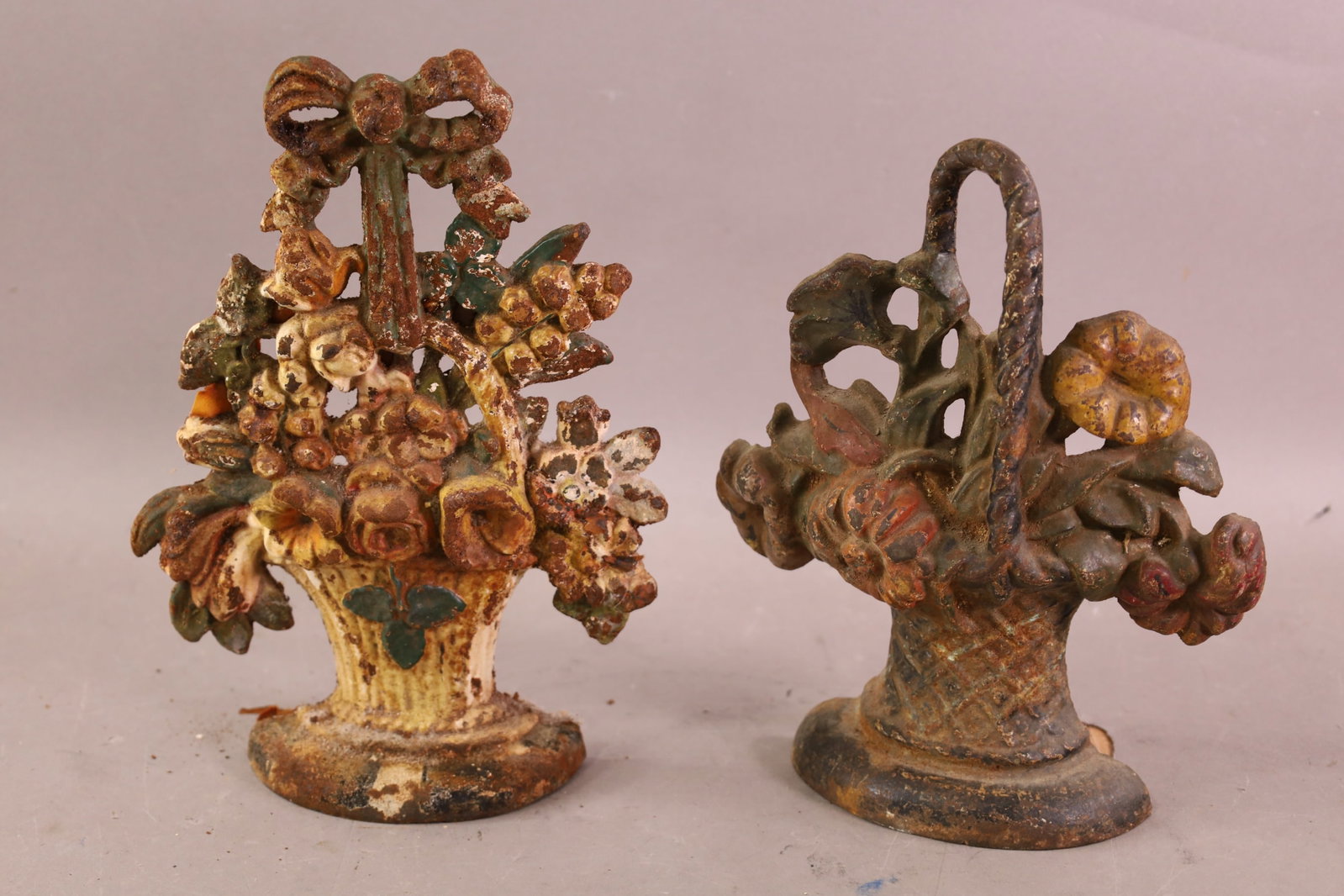 2 CAST IRON DOORSTOPS: FLOWER BASKET DOORSTOPS, RUST AND PAINT LOSS. 10" H.