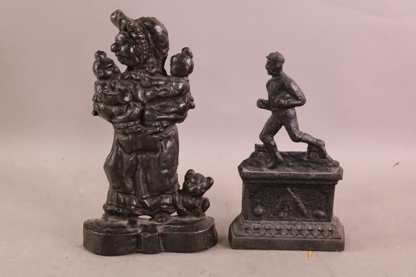 2 CAST IRON DOORSTOPS: MOTHER WITH CHILDREN & CRICKET PLAYER. 9" - 10" H.