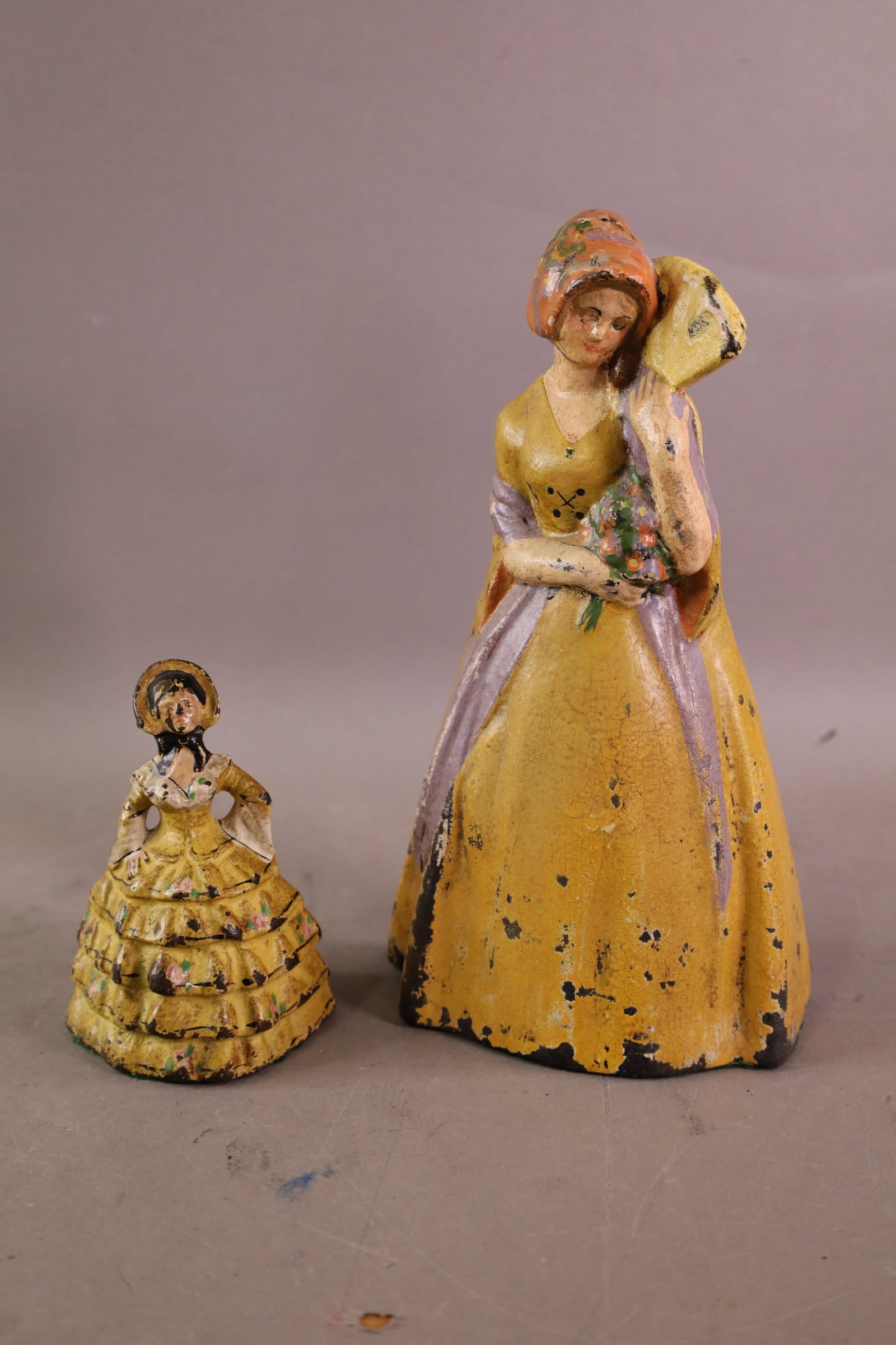 2 CAST IRON DOORSTOPS: LADY DOORSTOPS. PAINT LOSS. 5" - 10" H.