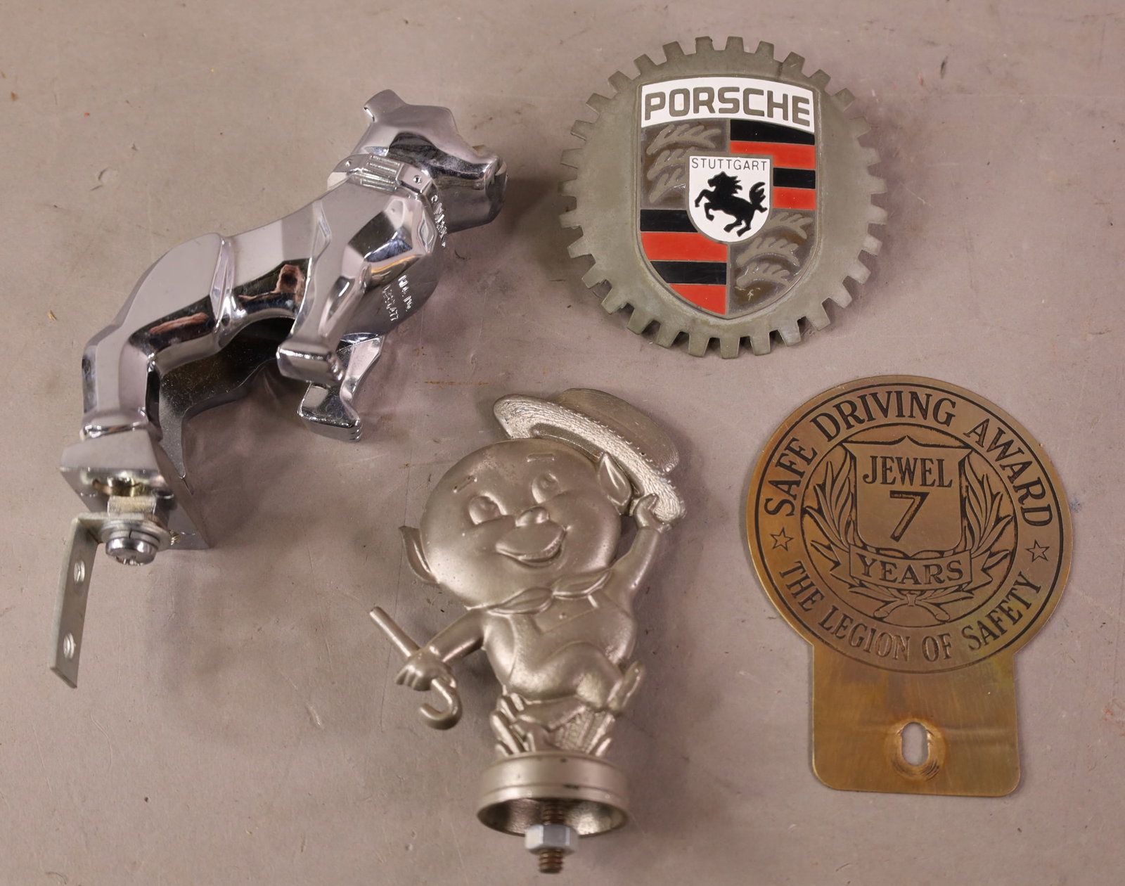 4 AUTOMOBILE ITEMS: MACK BULLDOG HOOD ORNAMENT, PORCSHE EMBLEM, LICENSE TOPPER & S.B. ORANGE SHOW