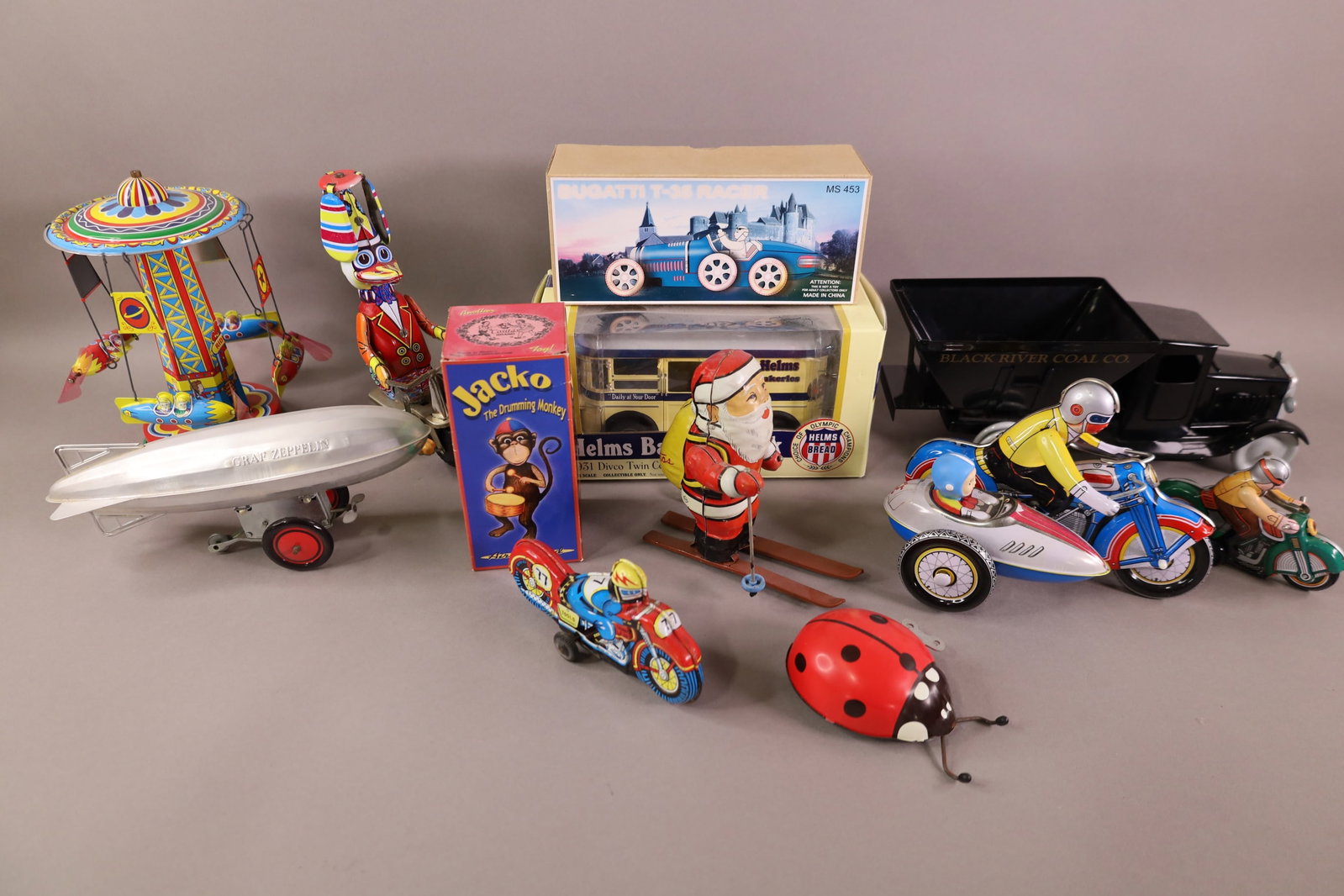 12 MISC. TOYS: COAL TRUCK, SANTA CLAUS, TIN LITHO MOTORCYCLES AND MORE.