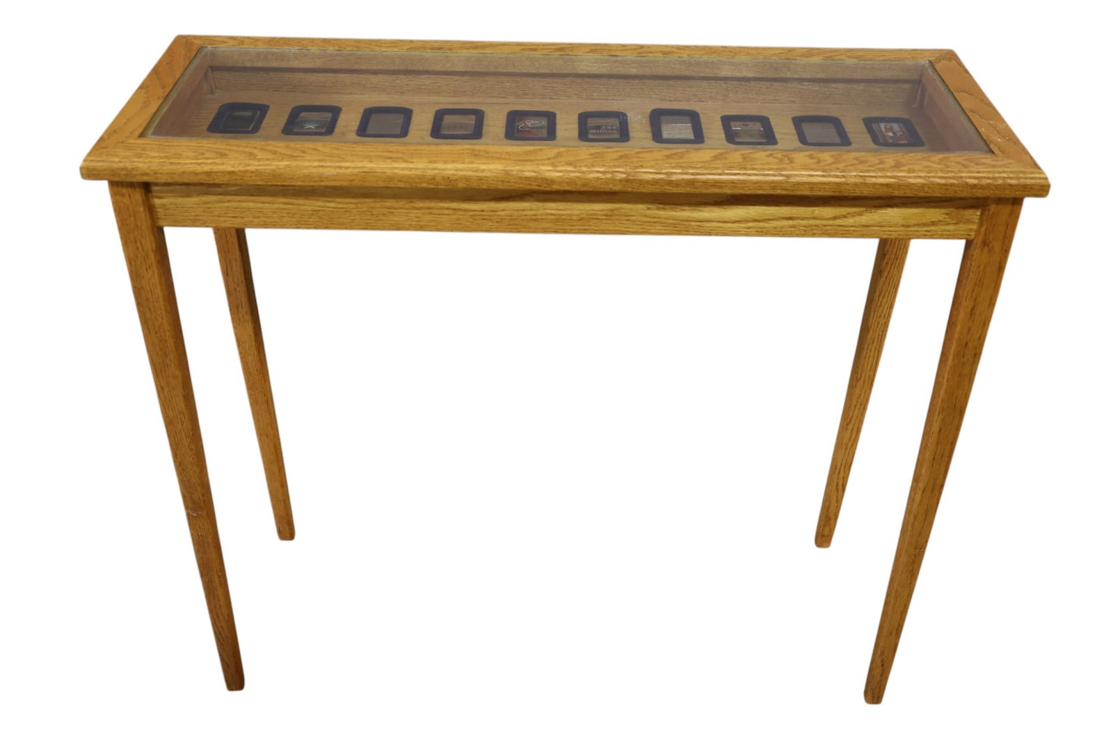 ZIPPO LIGHTER DISPLAY TABLE: GLASS TOP HALL TABLE, HINGED TOP, WITH ZIPPO DISPLAY. 20 ZIPPOS. 36" W x 13" D x 31" H. THIS ITEM EXCEEDS SIZE, WEIGHT, AND OR FRAGILITY LIMITATIONS FOR IN HOUSE SHIPPING, MUST BE PICKED UP IN HOUSE