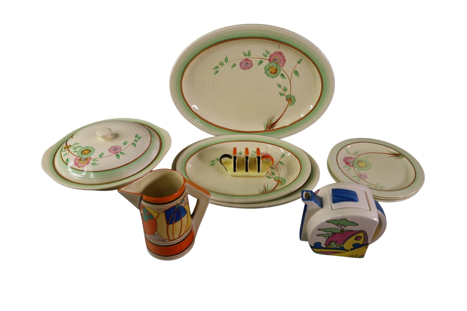 CLARICE CLIFF ENGLISH PROCELAIN: TEA POT, PITCHER, PLATTERS. LID HAS CRACK. SOME IS CONTEMPORARY. 14" W.